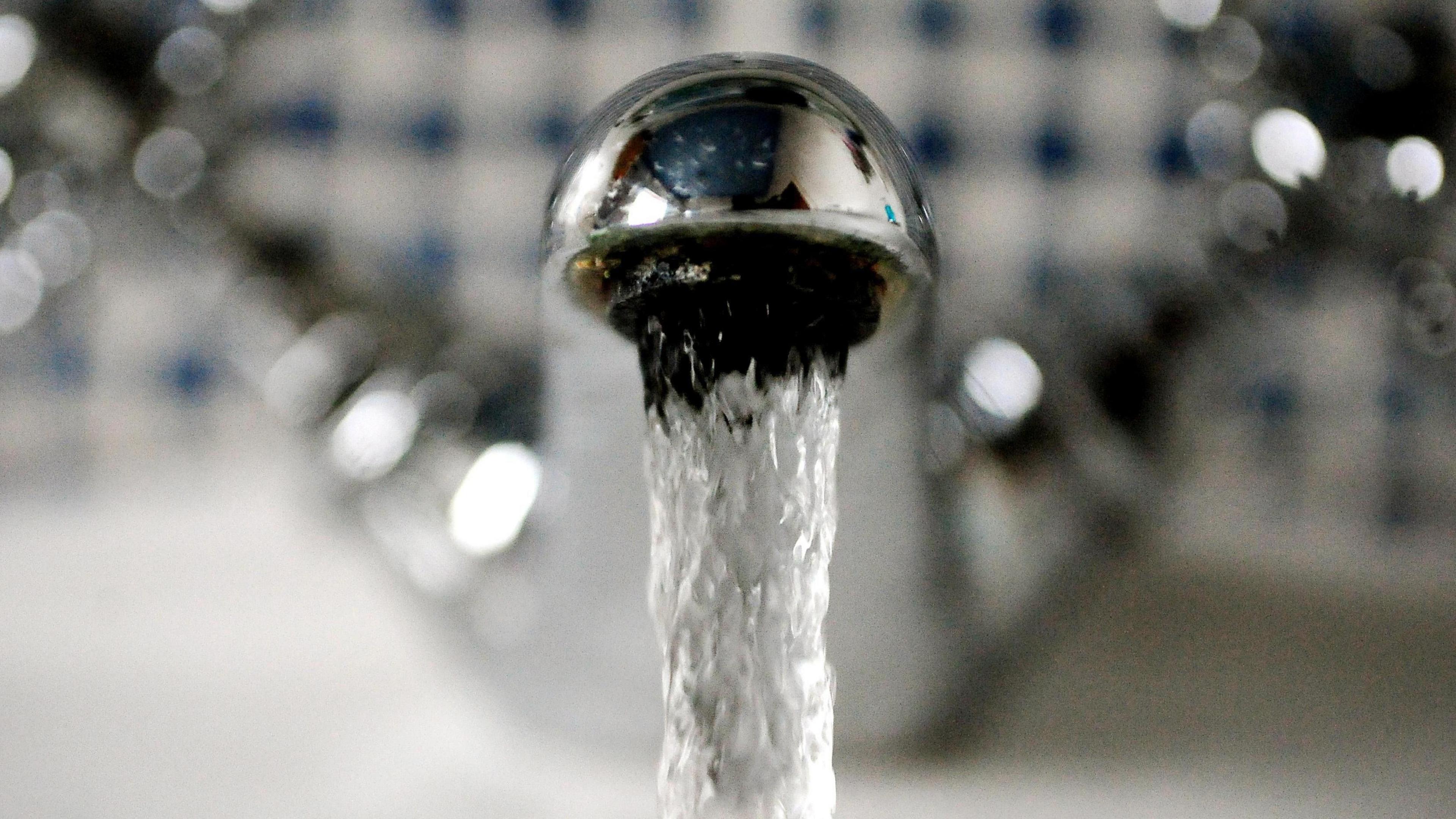 A picture of water running from a silver tap.