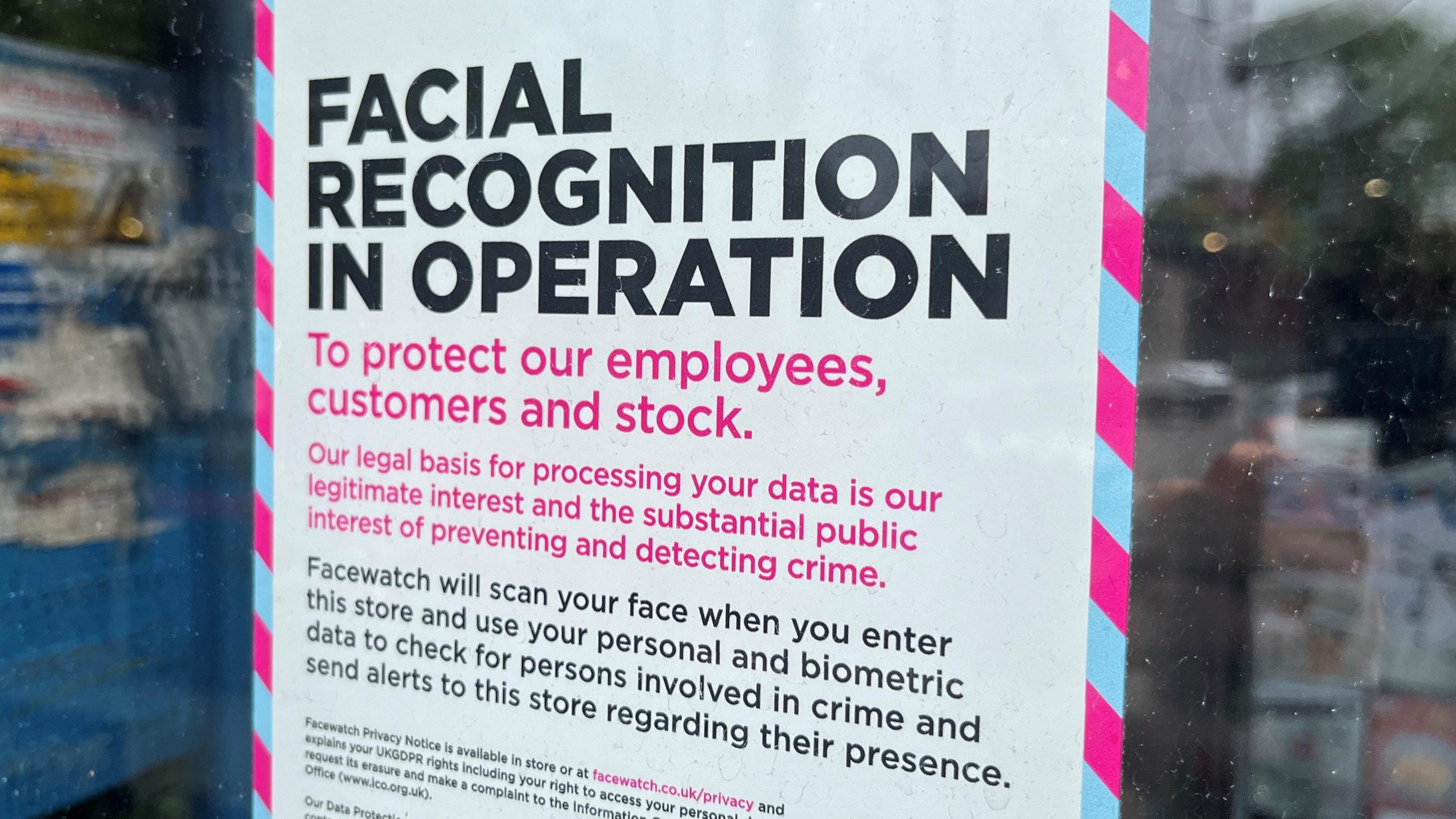 Poster sign on a shop window saying "Facial recognition in operation to protect our employees, customers and stock. Our legal basis for processing your data is our legitimate interest and the substantial public interest of preventing and detecting crime."