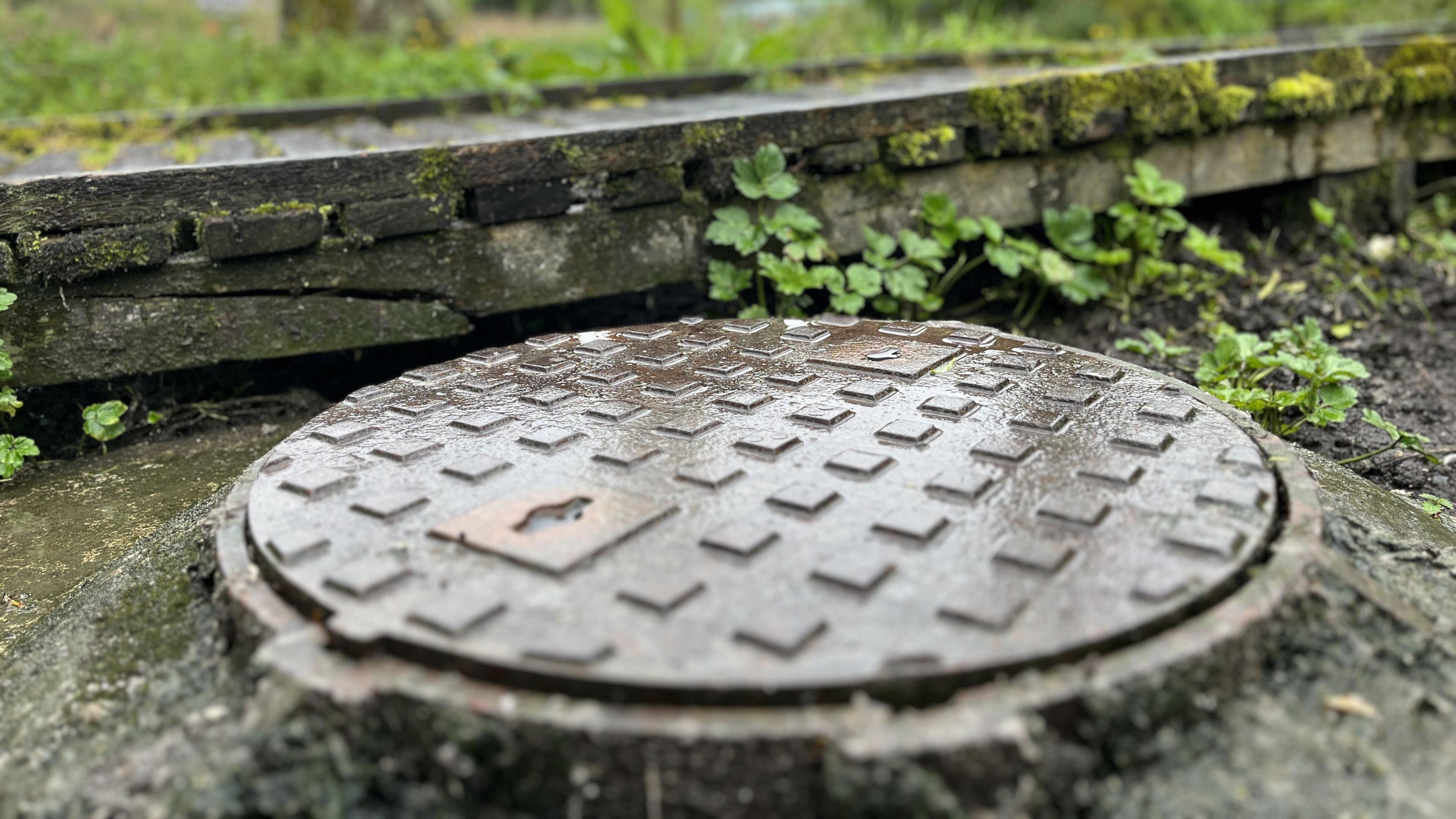 Man hole cover at the edge of the River Kennet