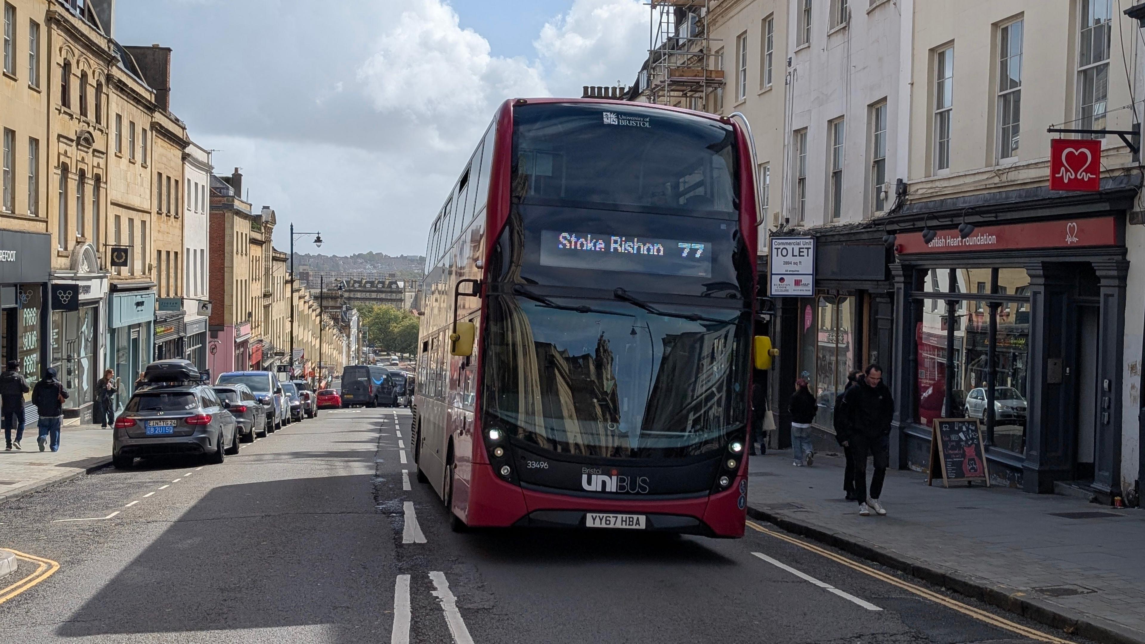A red bus drives up Park Street in Bristol