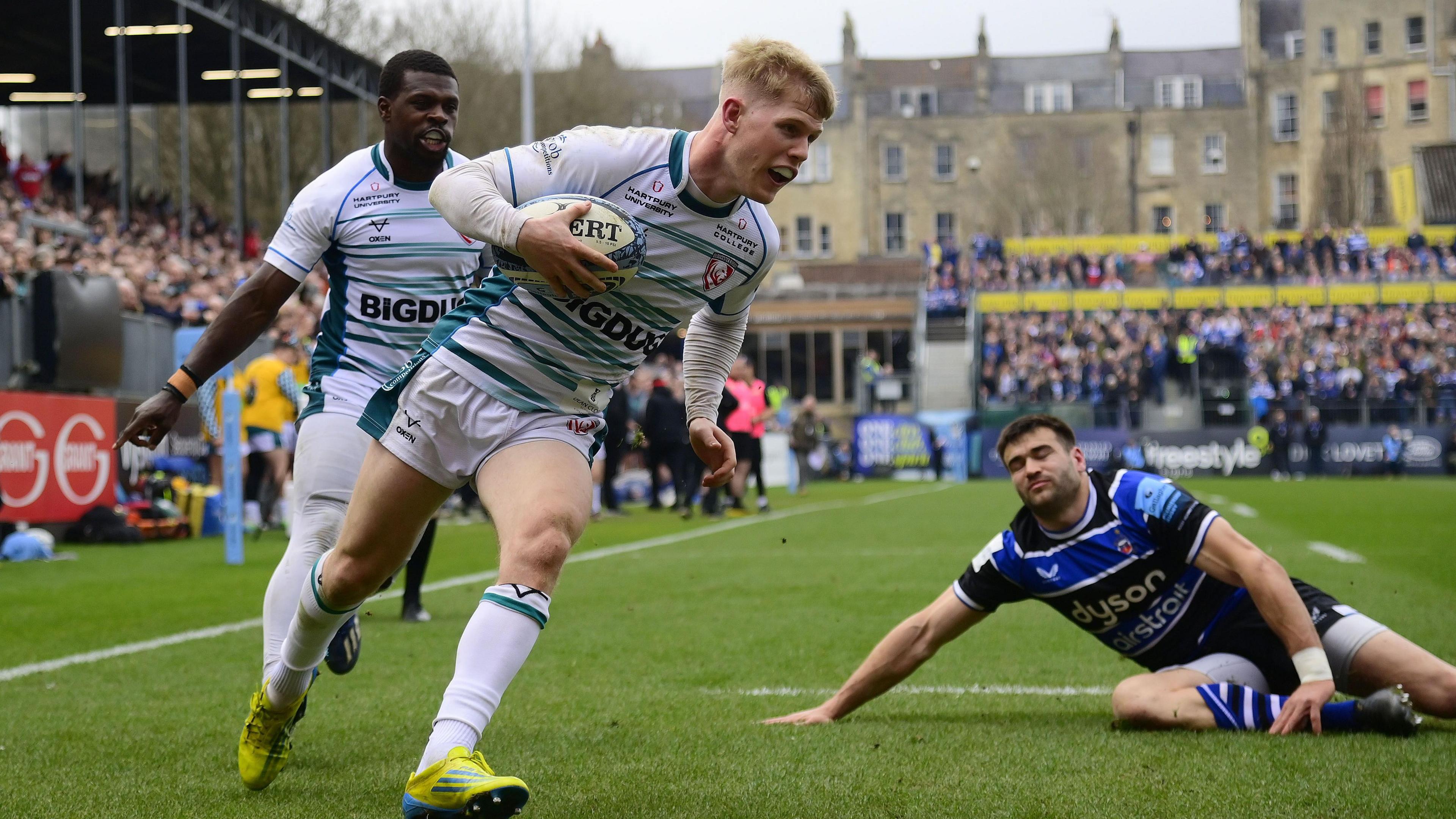 George Barton (centre) scores a try for Gloucester