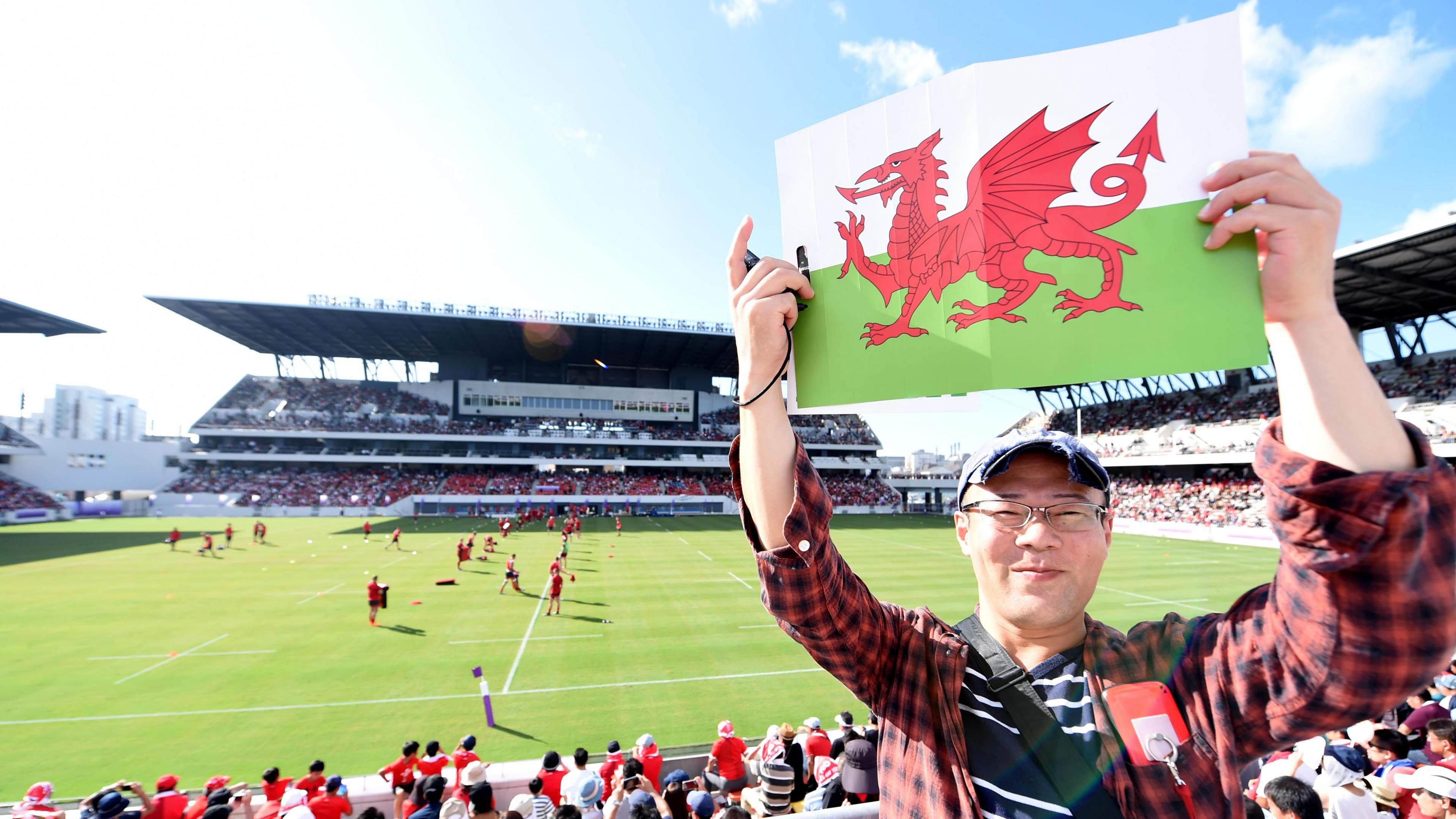 A Japan rugby supporter with the Wales flag