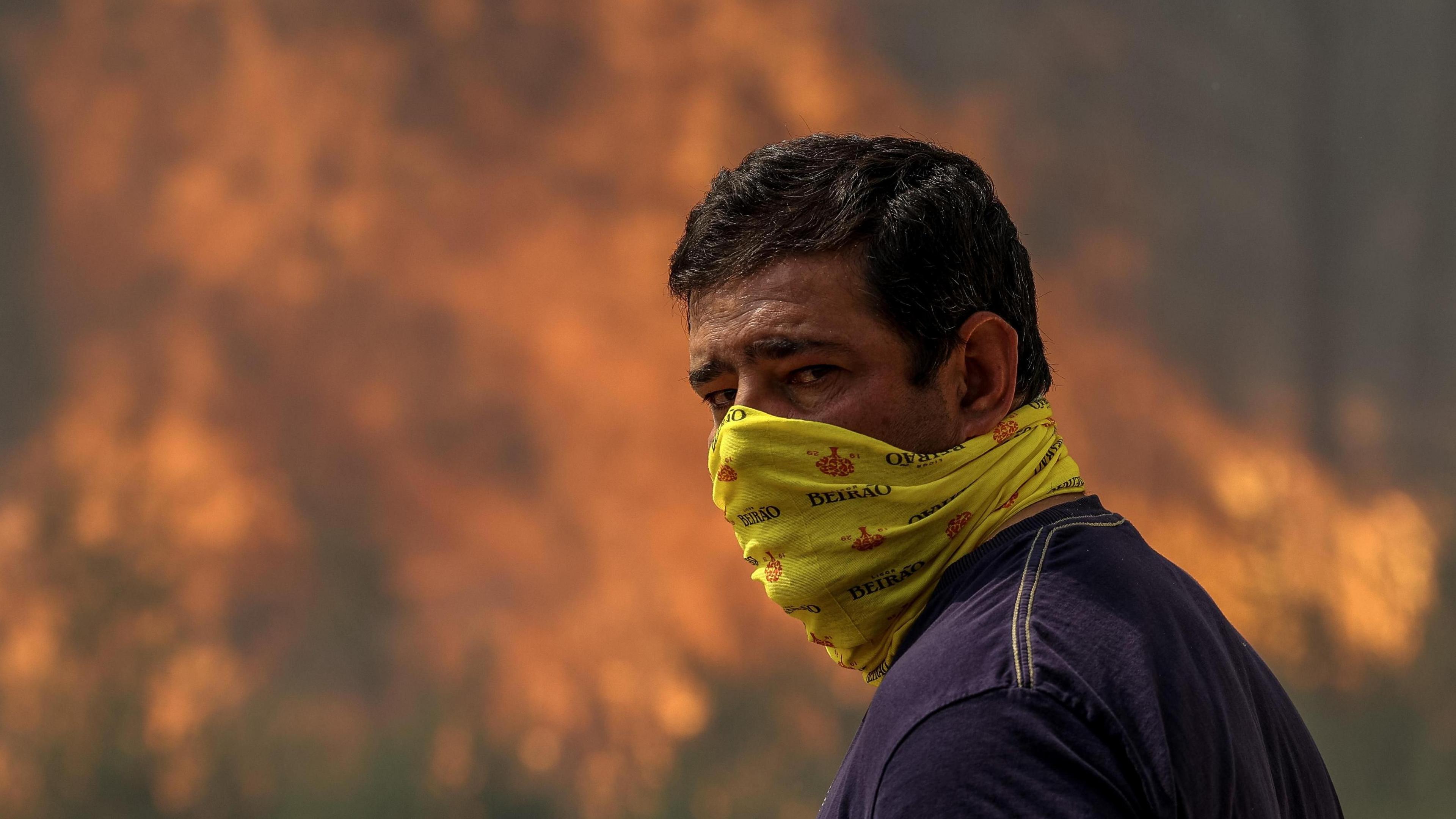 A man looks on as a forest fire burns in Soutelo, Albergaria-a-Velha, Portugal