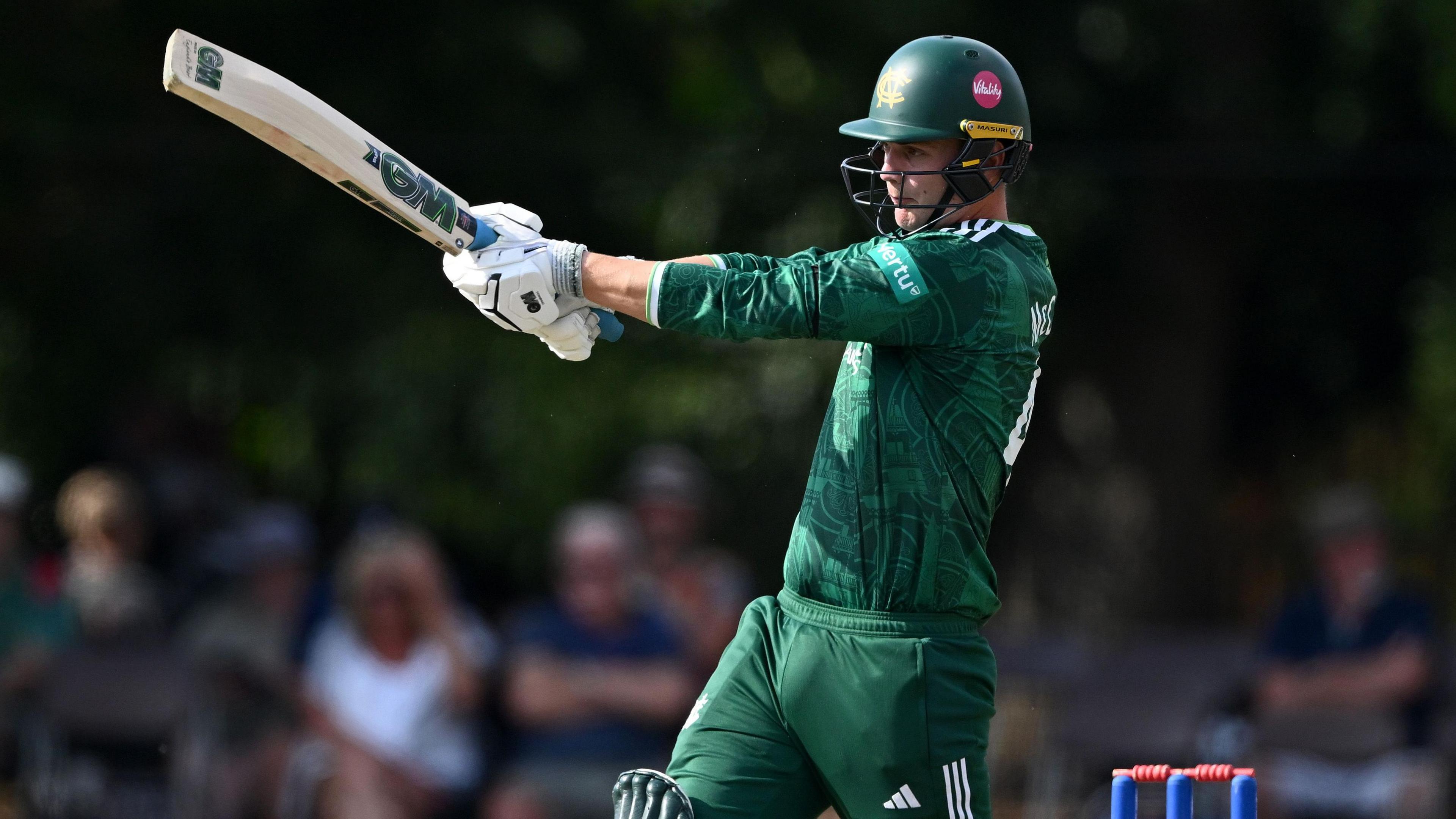 Freddie McCann is pictured in green Nottinghamshire kit playing a shot with his bat during the win over Northamptonshire at Chesterfield on Friday 7 August 2026