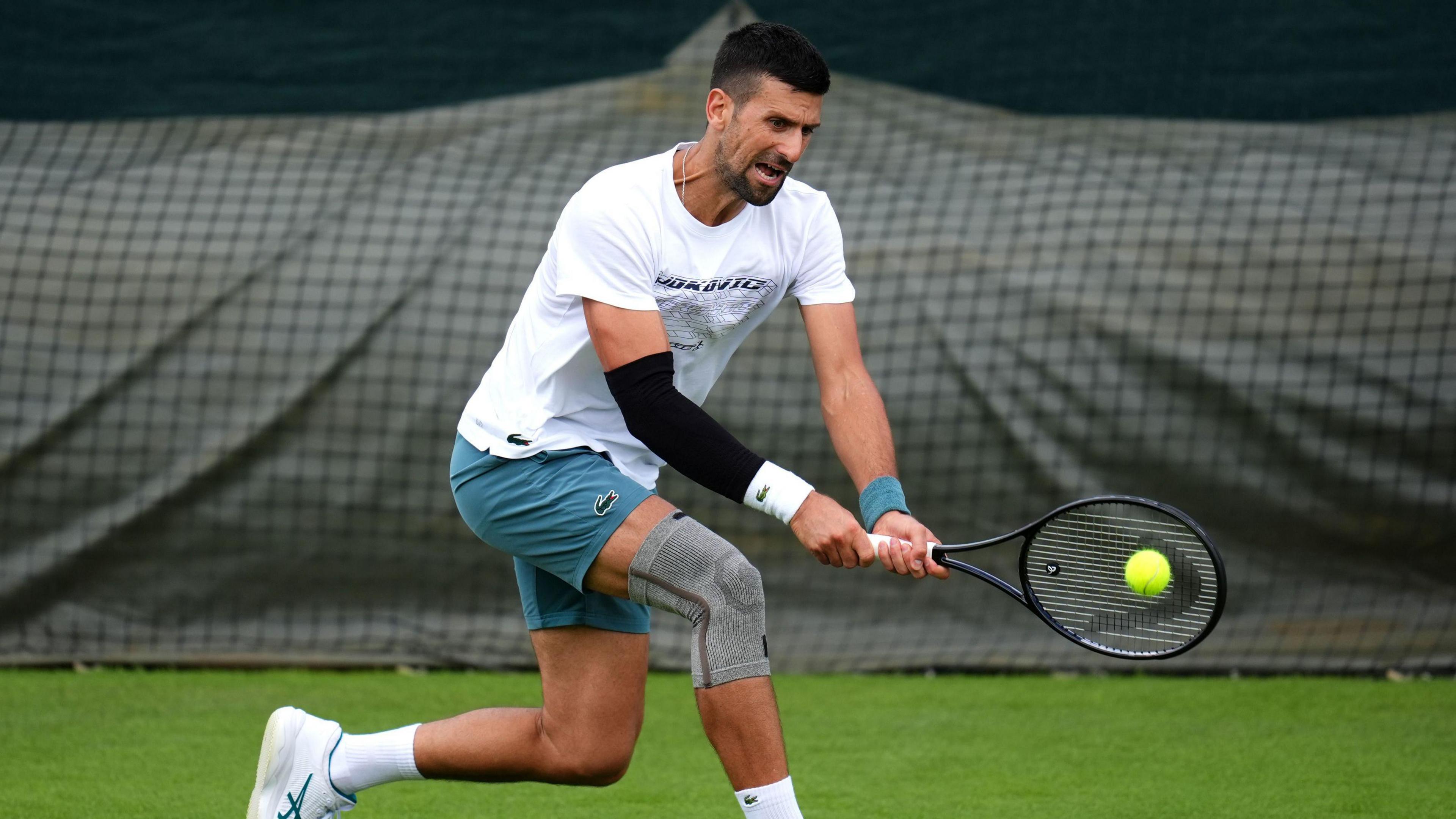 Novak Djokovic hits a backhand during practice at Wimbledon on Monday