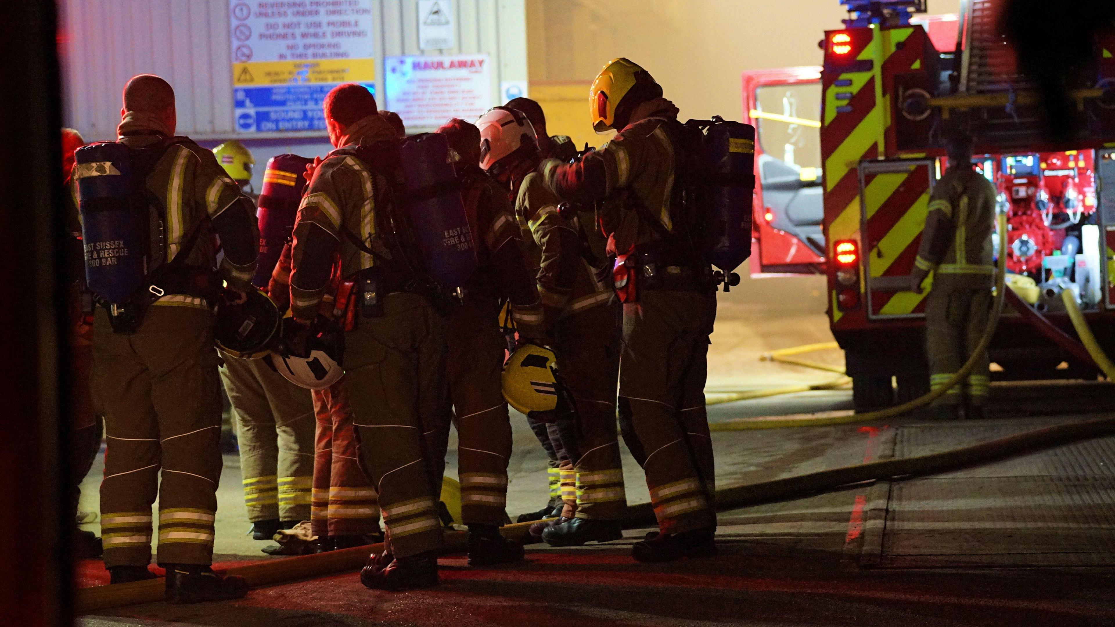 Several firefighters talk in a group