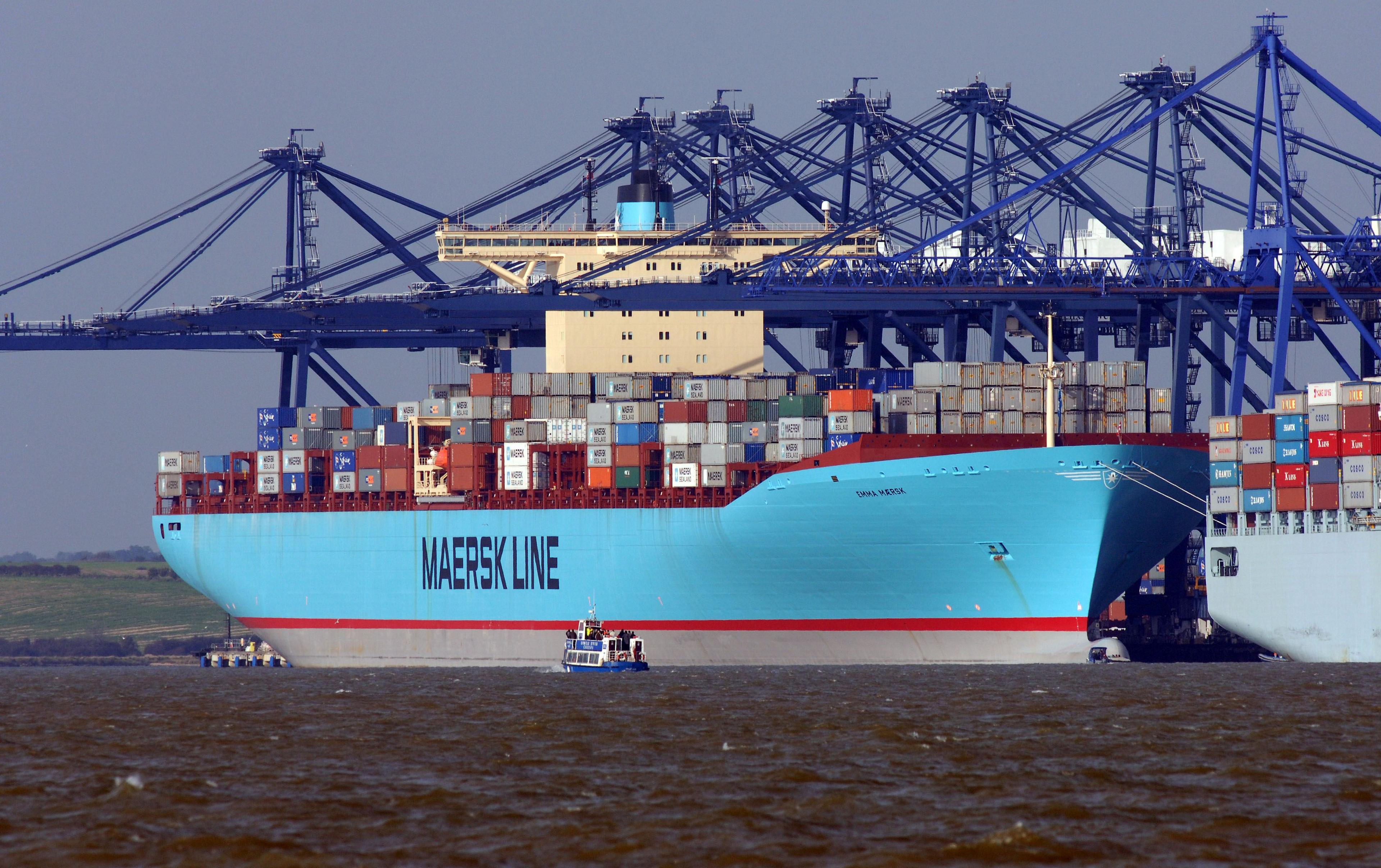 A Maersk container ship docked at the Port of Felixstowe with blue cranes over it.