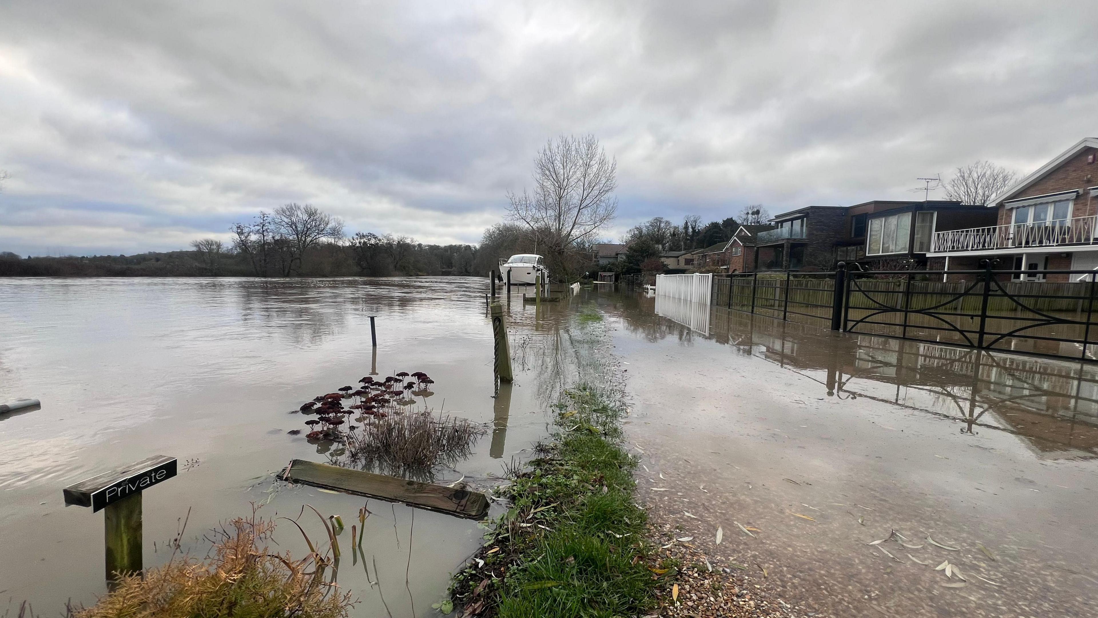 Homes on the right hand side of the picture, with the River Thames, which has broken its banks, flowing over the land 