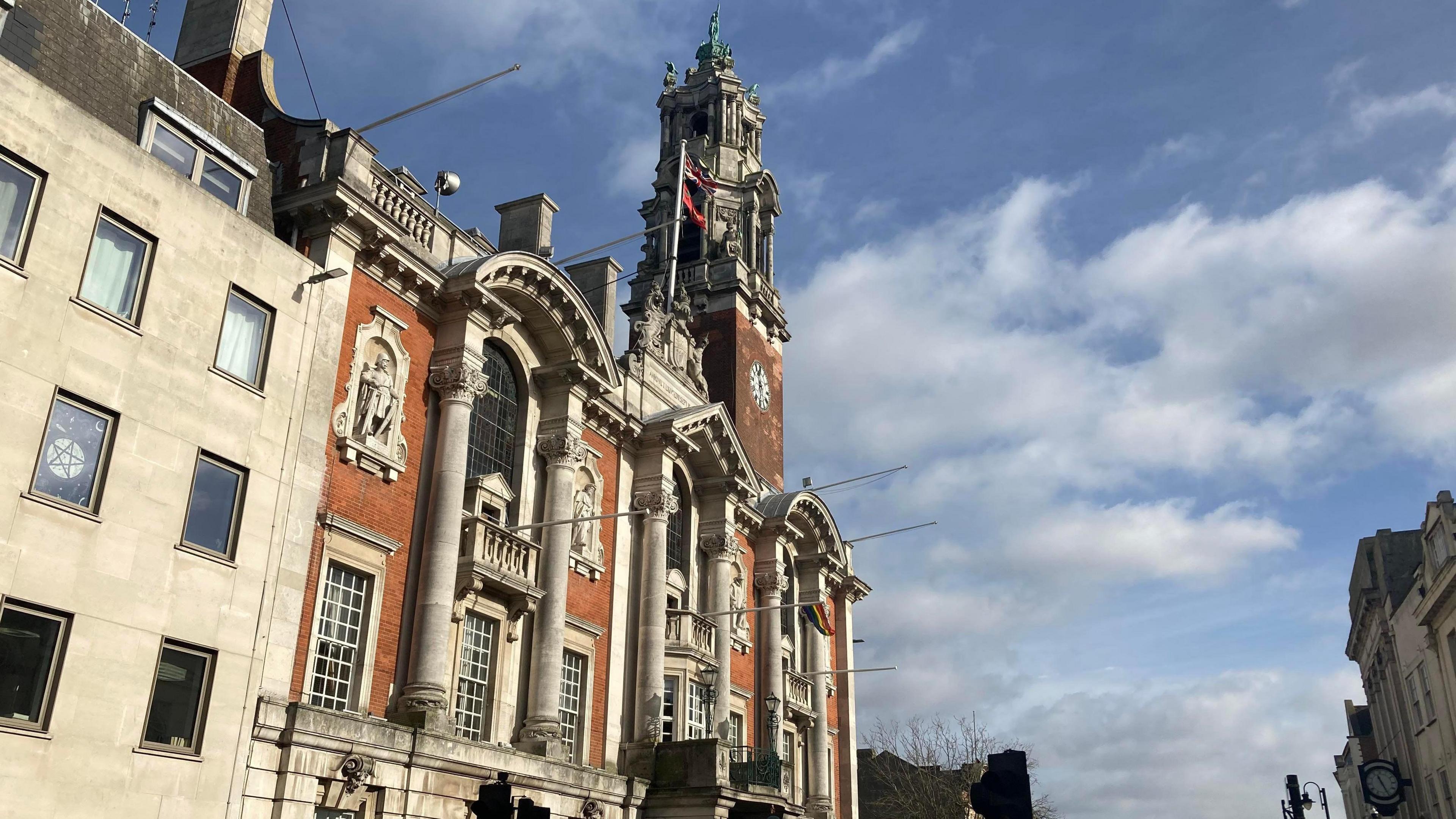 A general view of the exterior of Colchester Town Hall. The building extends over four storeys and has large windows and architectural details on its face.