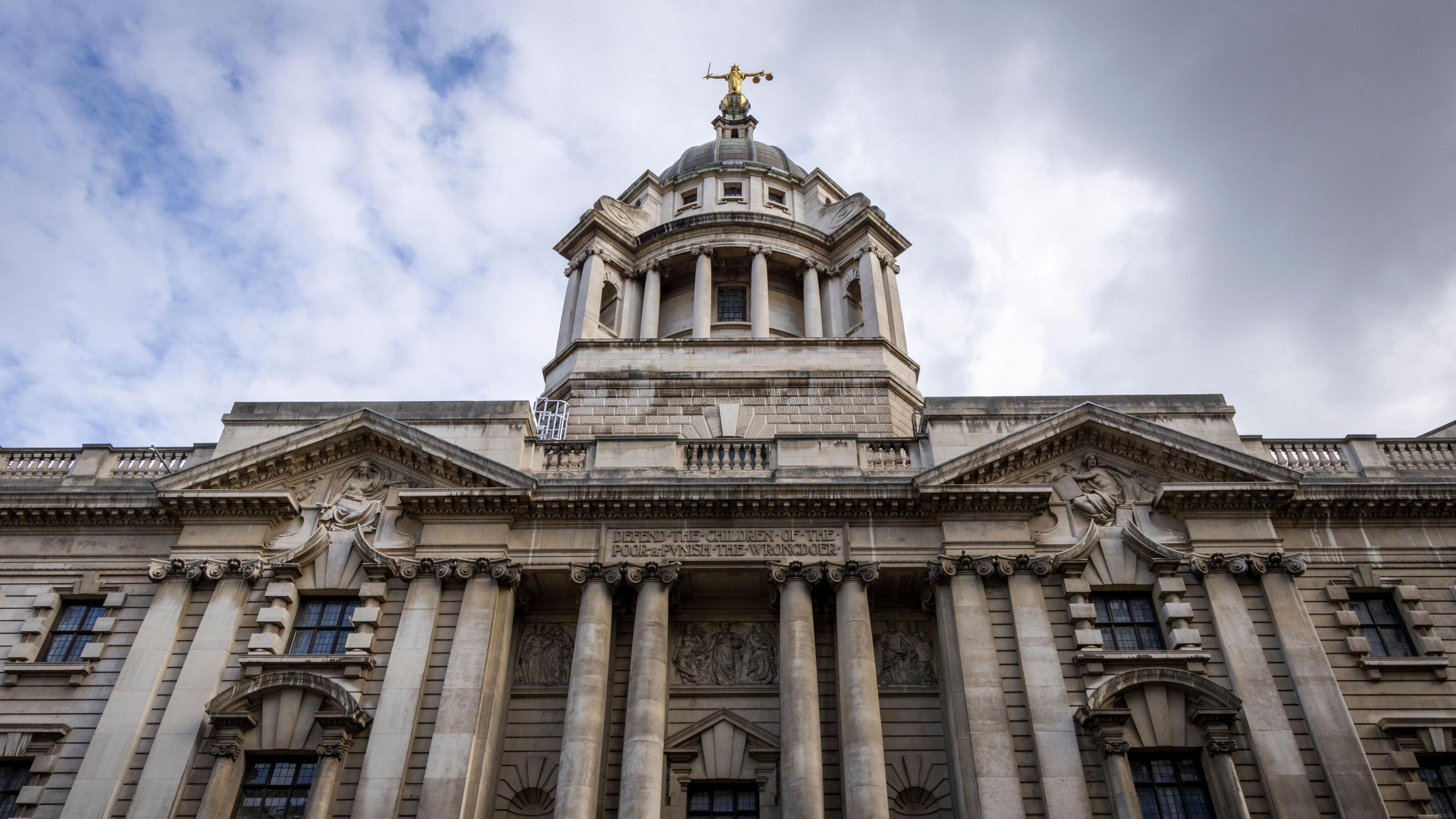 The outside of the Old Bailey court, a large grey building with a golden statue on top