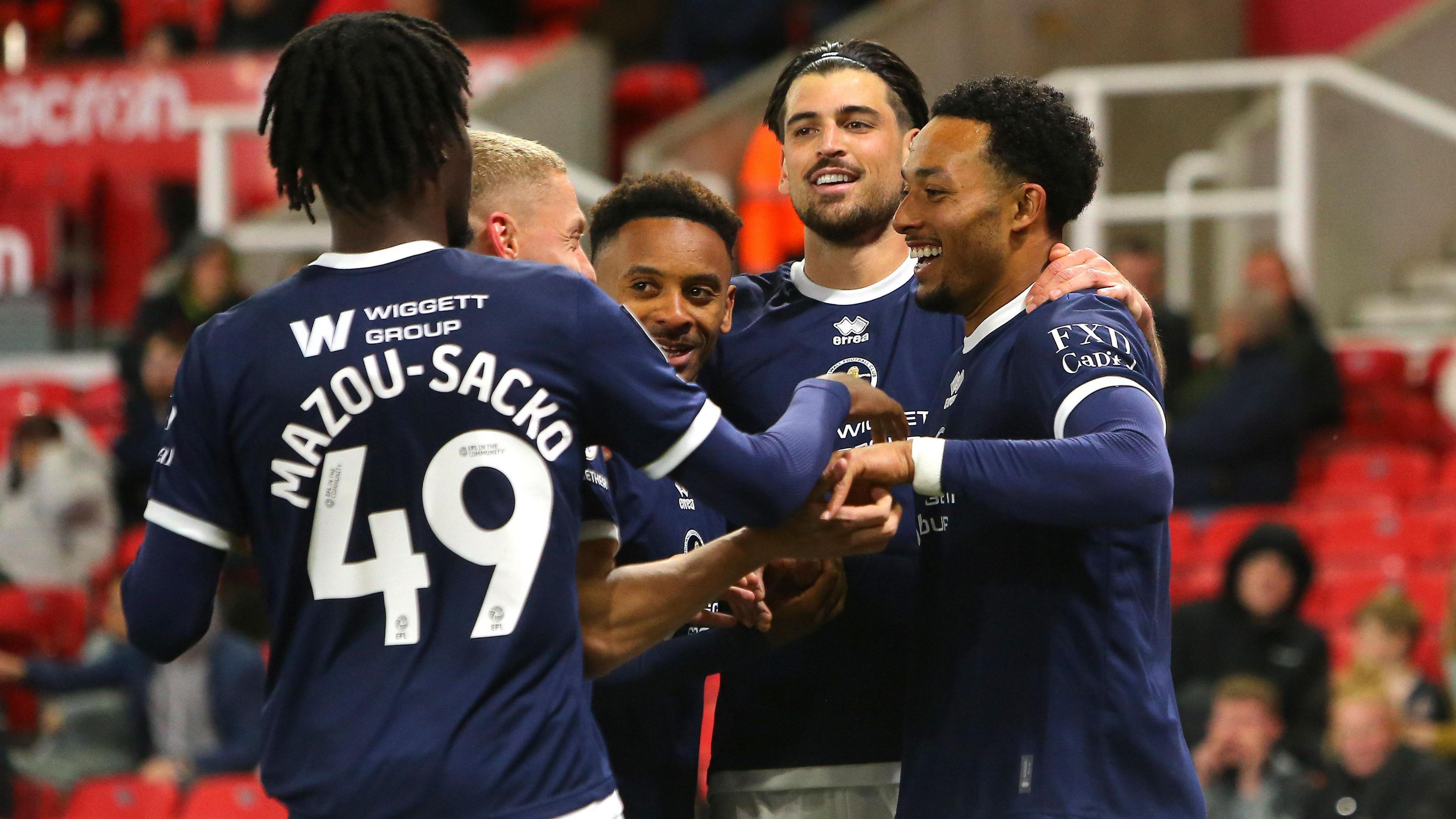 Millwall players celebrate in a huddle