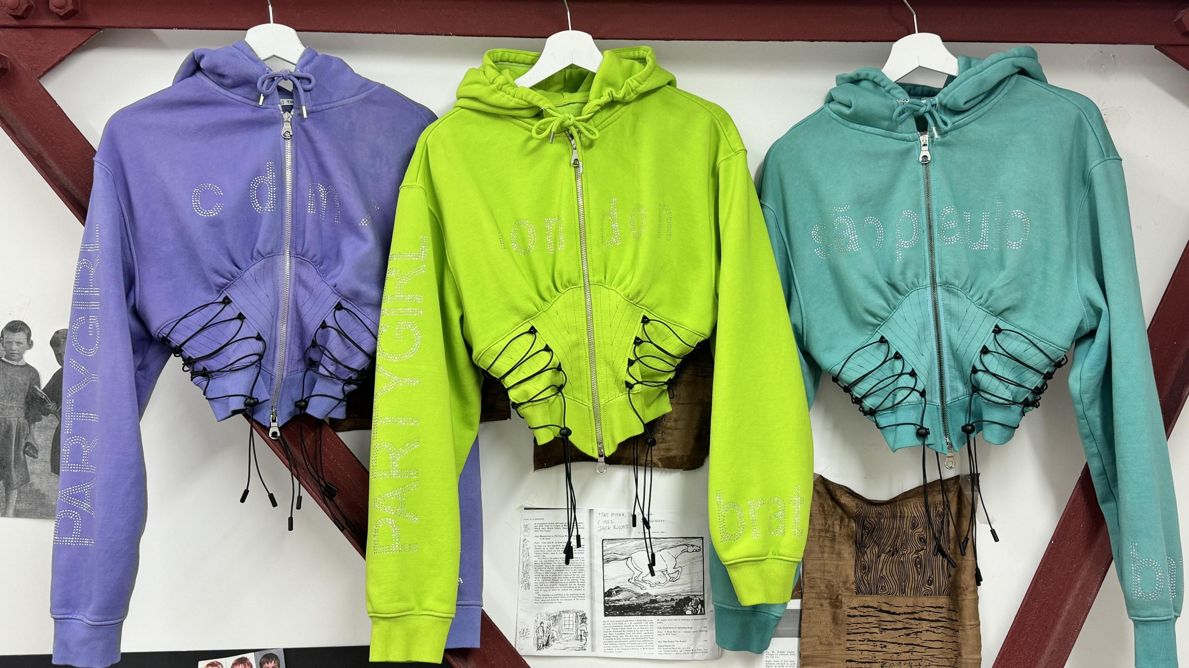 Three hoodies, one purple, one green and one blue