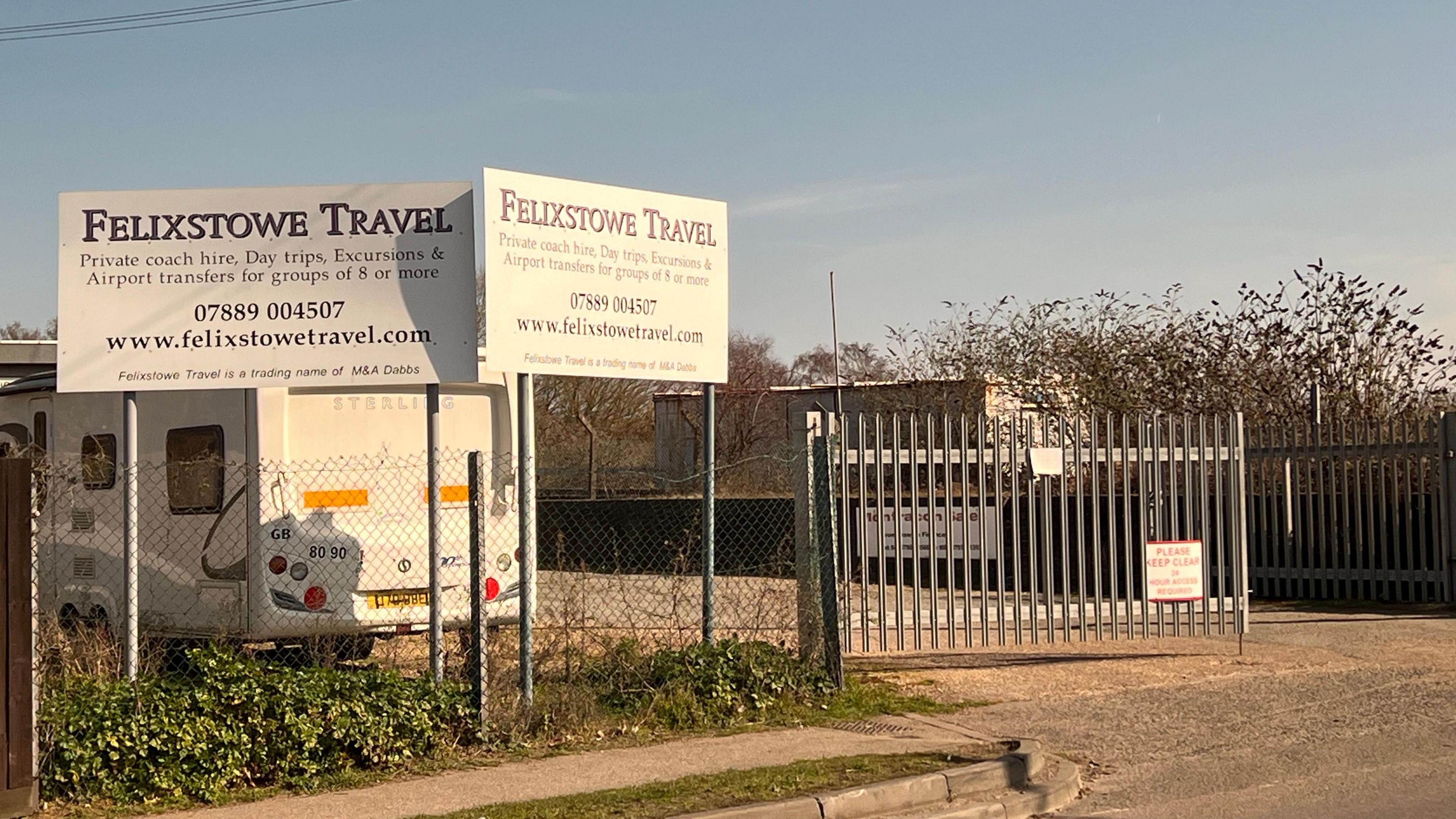 The outside of the yard where Felixstowe Travel operated. There are two branded signs on the other side of the fence.