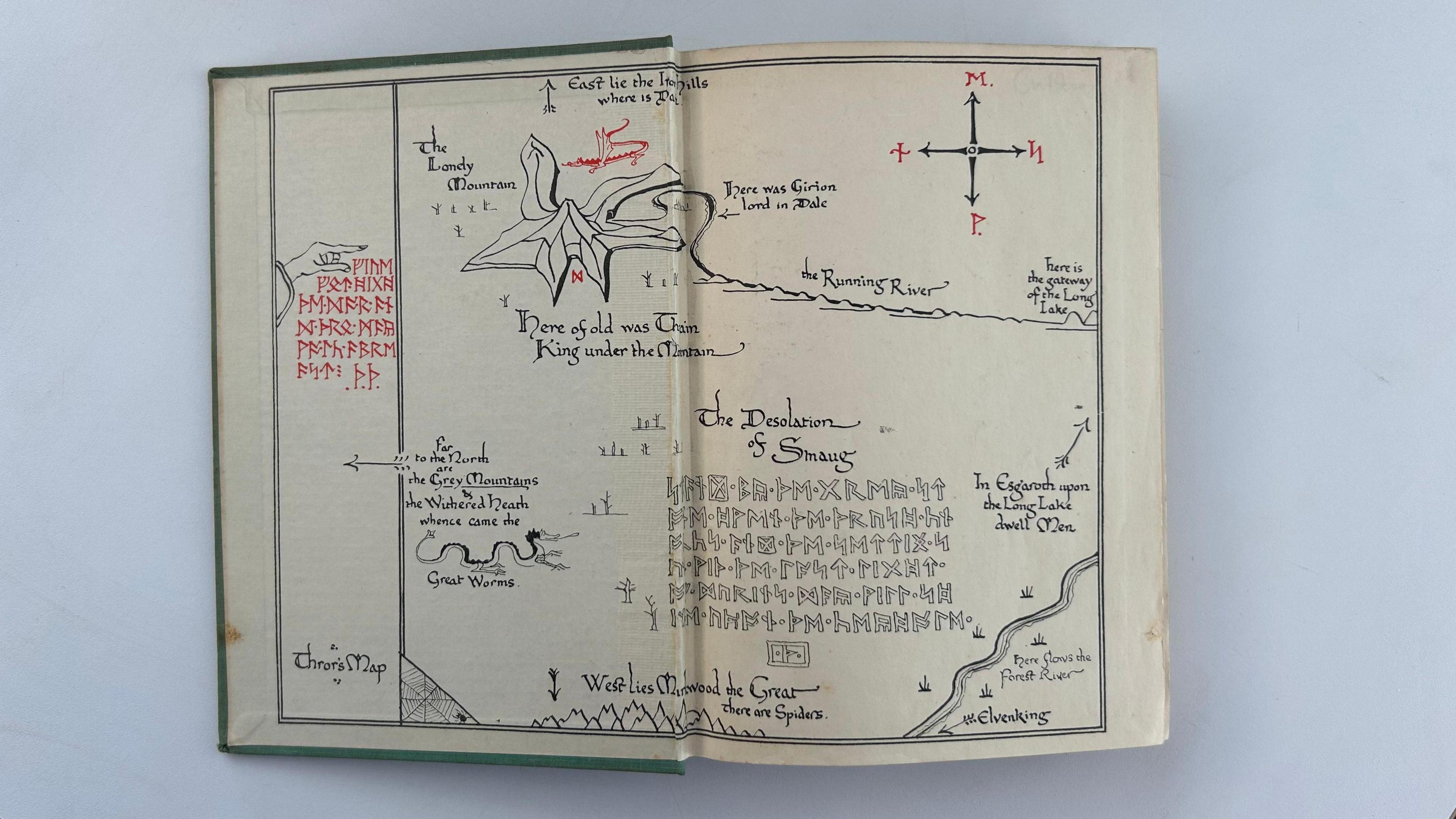 A drawing in the book of a map and some runes. The drawing is mostly black, with some red runes.