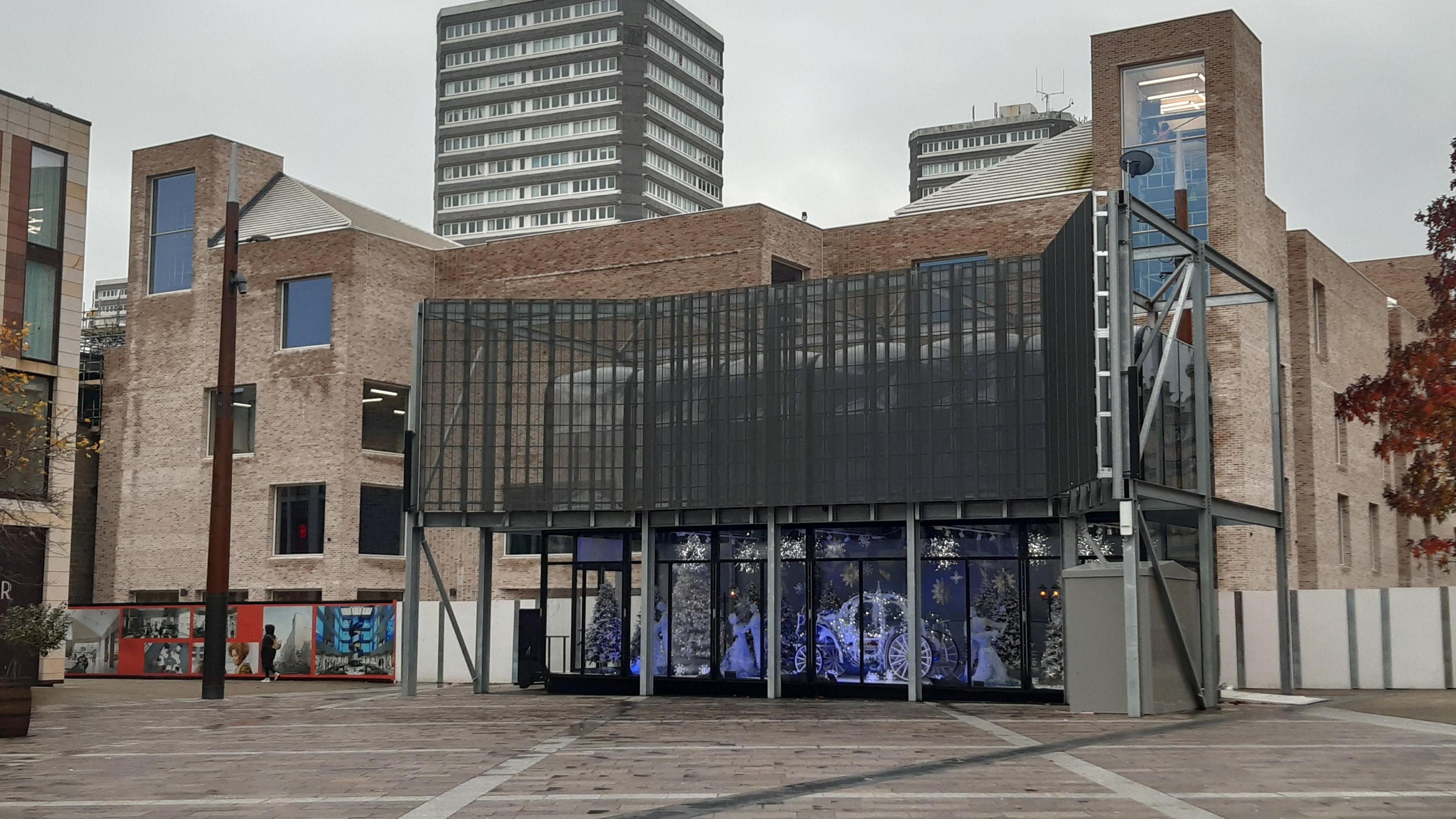 Culture House, photographed from Keel Square. It is a multi-storey brick building with a lot of windows. There is a large screen in front of it.