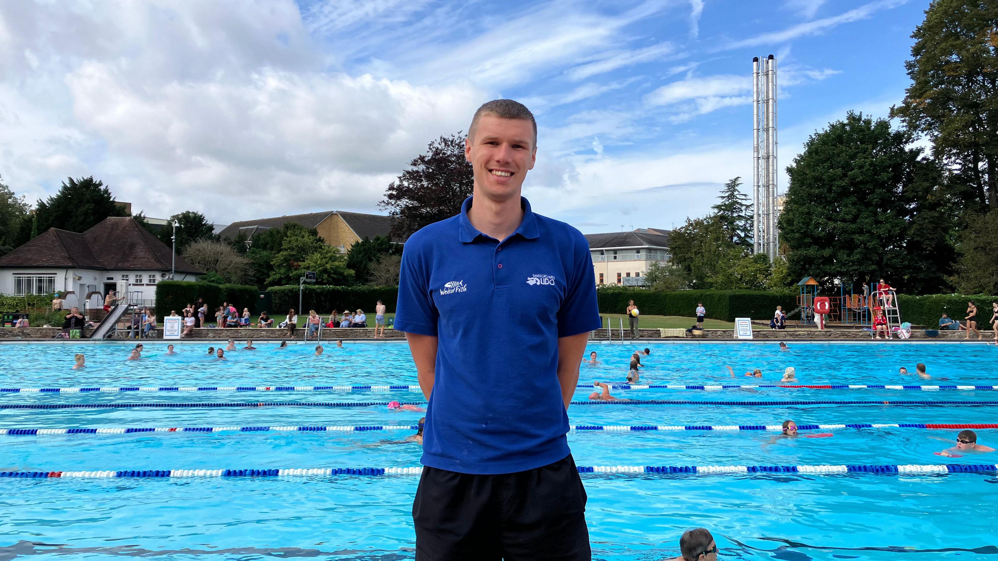 Man standing in front of outdoor swimming pool