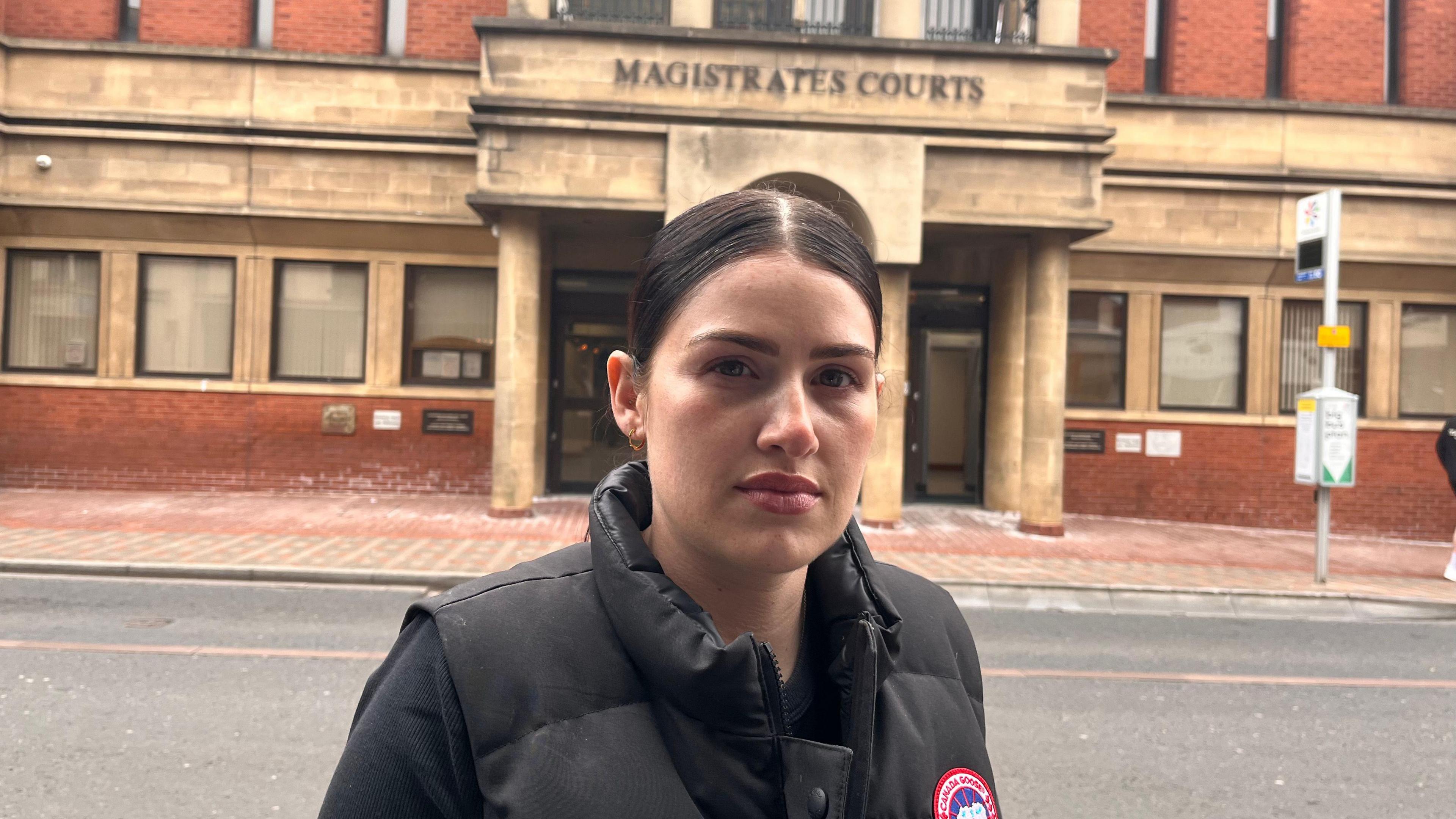 Chloe Mefford, dressed in black, stands outside Leicester Magistrates Court