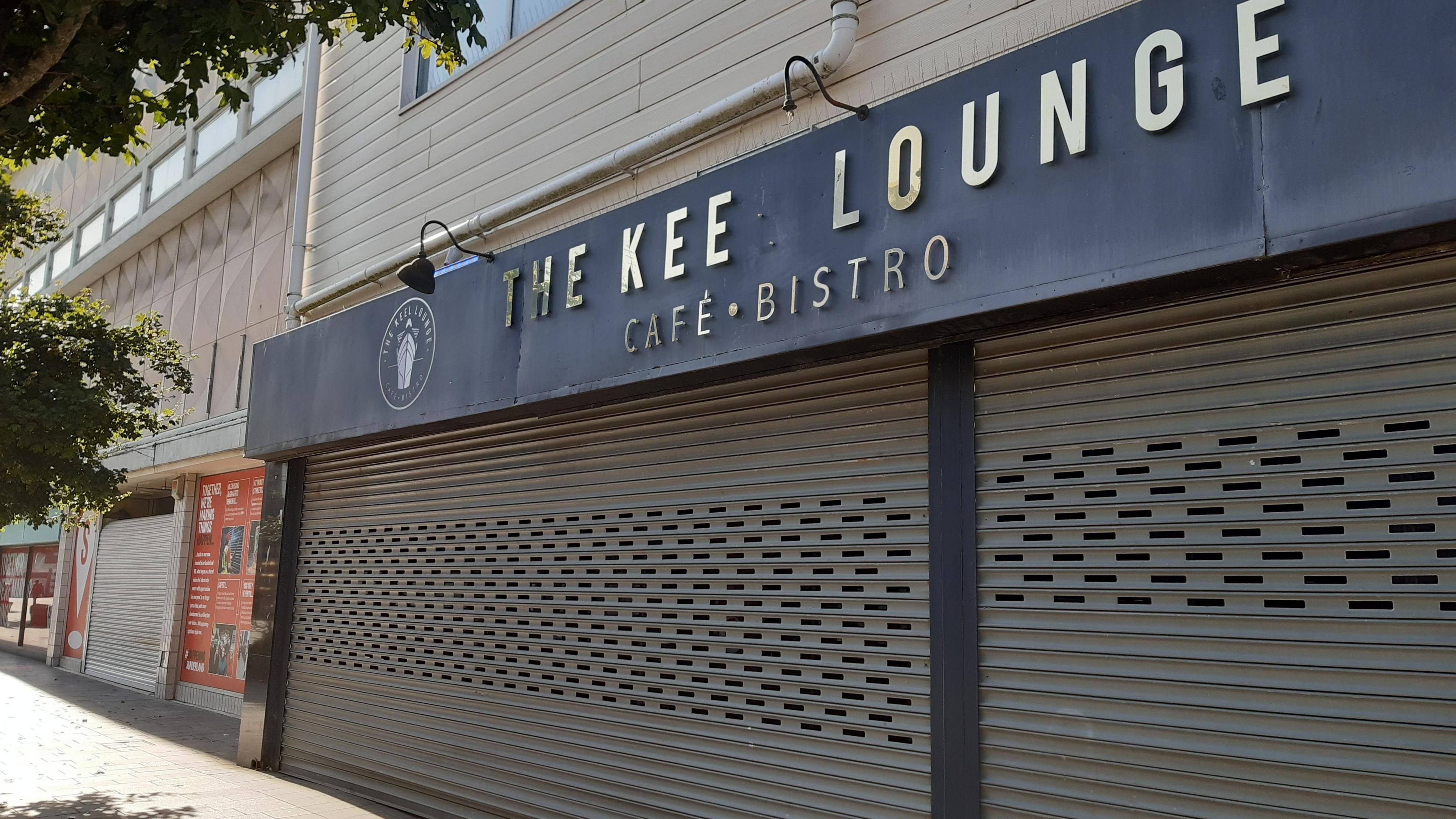 The Keel Lounge Cafe and Bistro. The shutters of the cafe are down as it is closed. The L is missing from the word Keel in its signage.