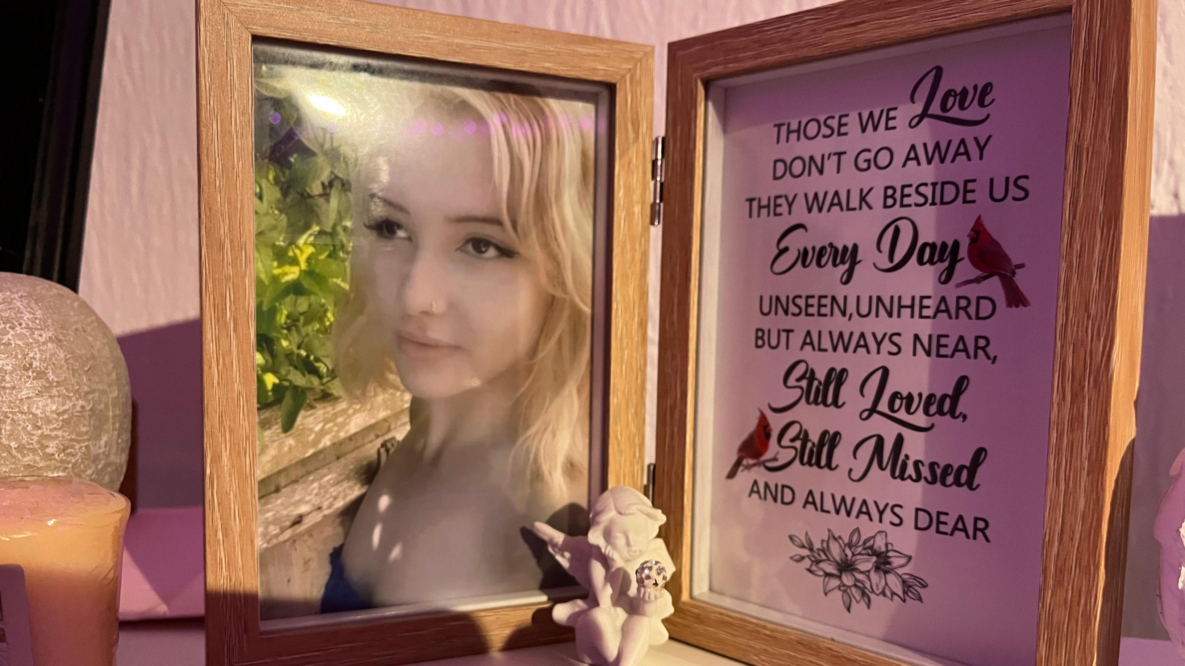 A double photo frame - on the left is Phoebe (a young girl with blonde hair) and on the right is a message reading 
"Those we love
Don't go away
They walk beside us every day
Unseen, unheard
But always near,
Still loved, 
Still missed
And always dear"