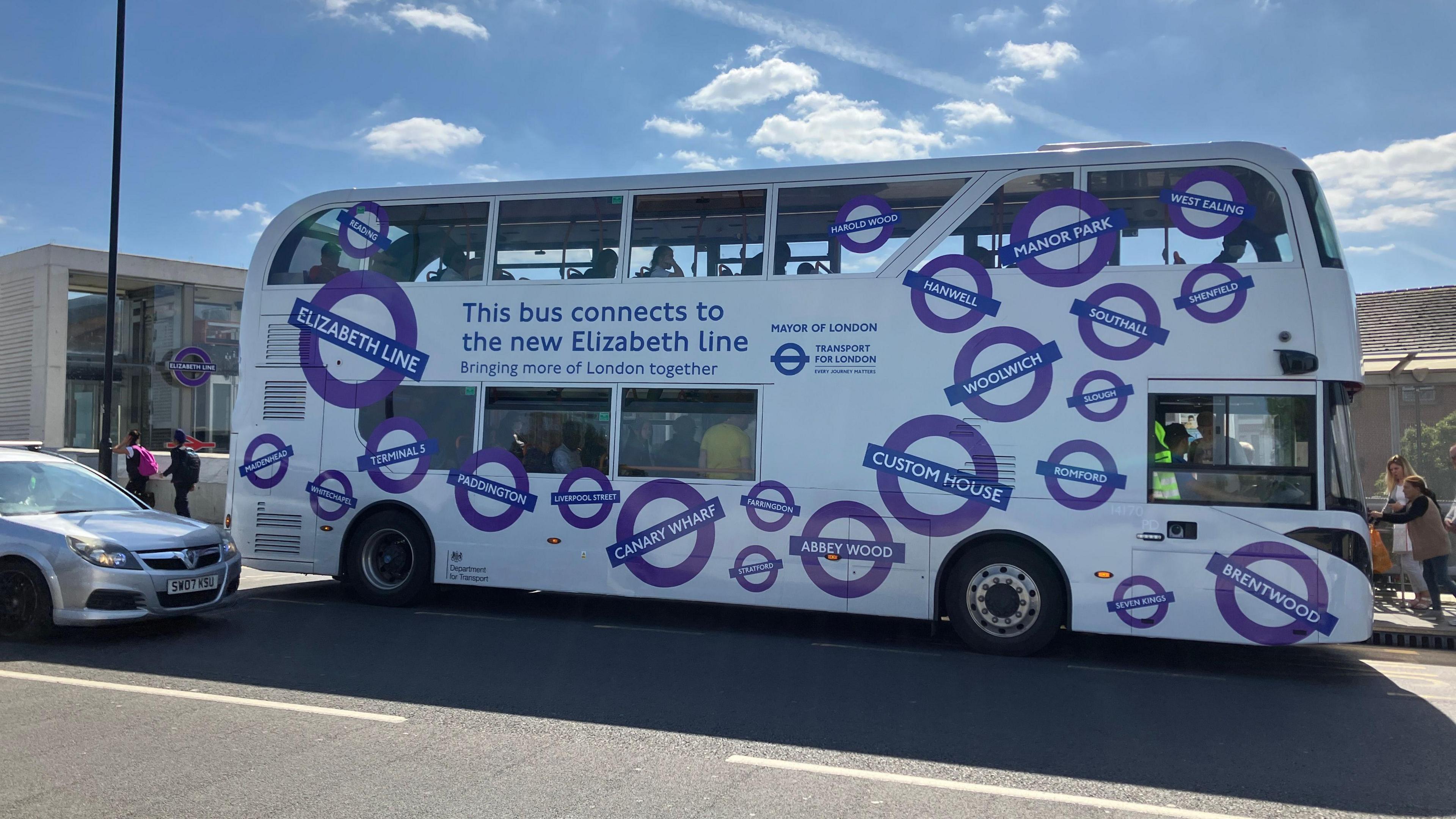 Double decker bus outside Abbey Wood station. There is a banner on the side that reads, "This bus connects to the new Elizabeth line".