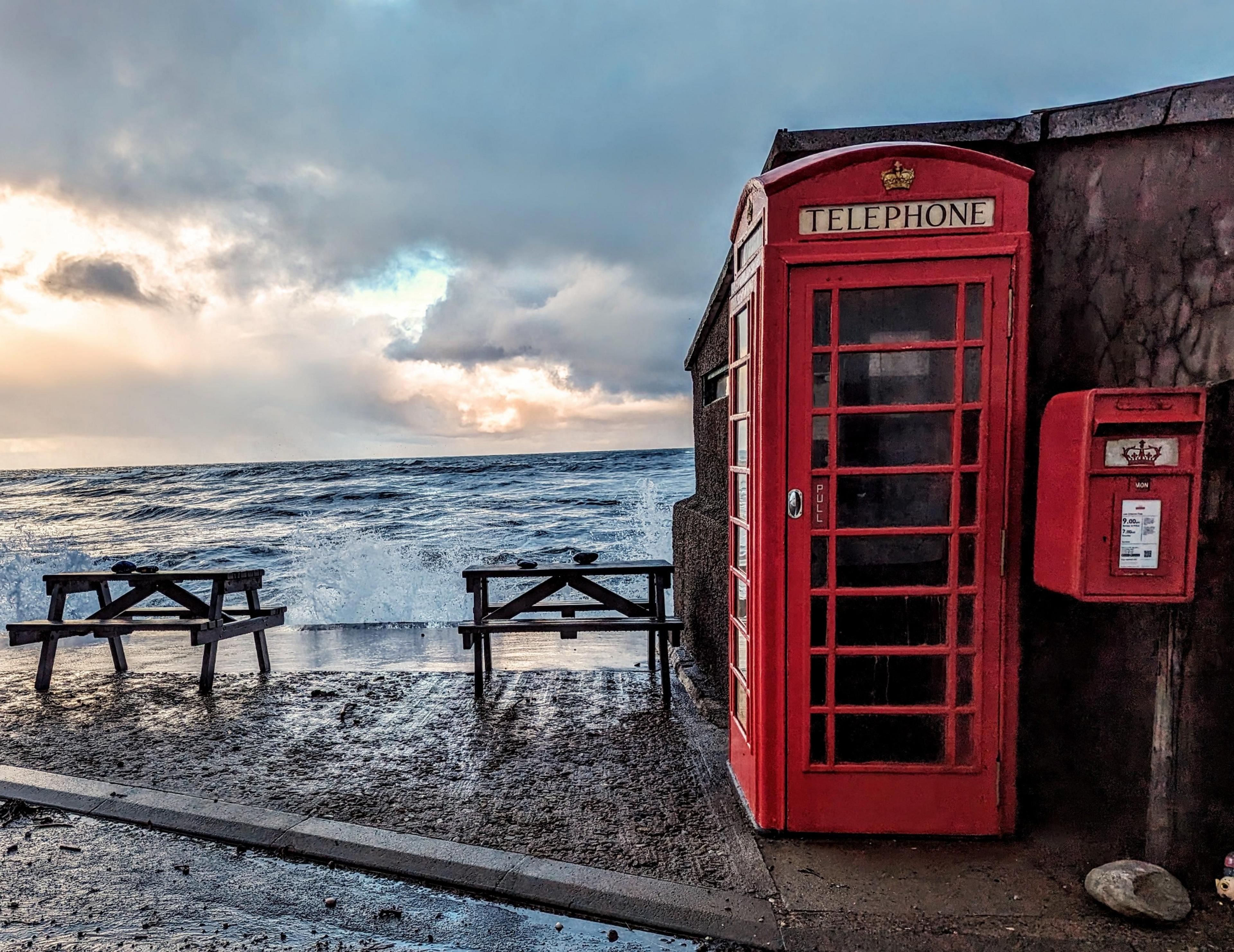 Red phone box by the sea