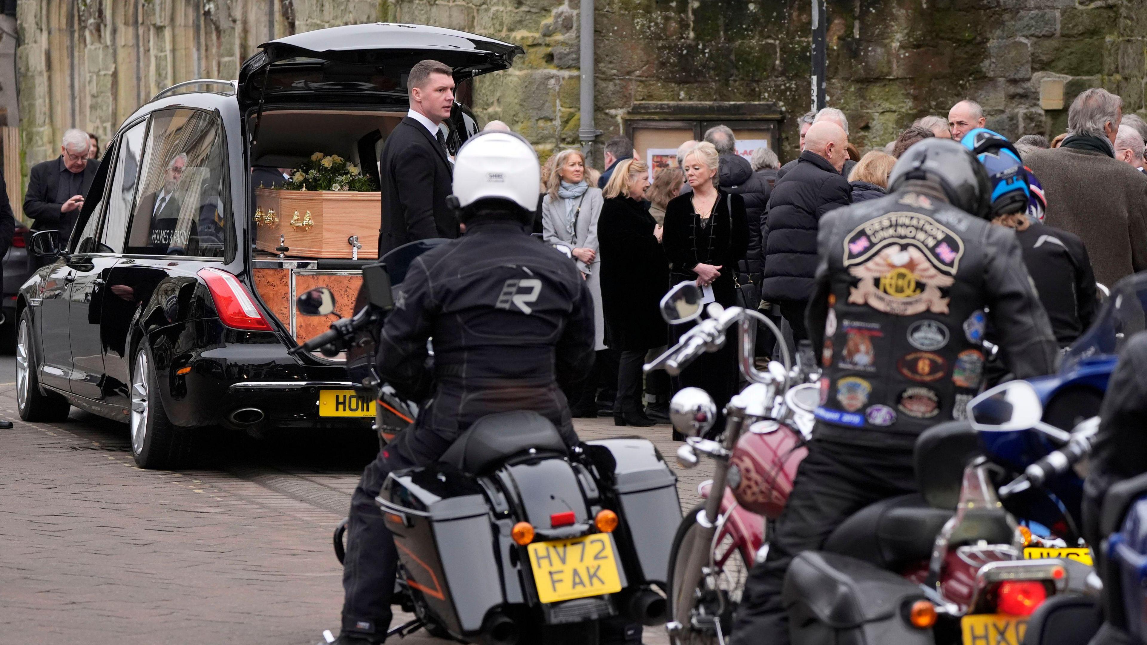 Harley Davidson riders gather behind the hearse to take part in a tribute following the funeral of DJ Johnnie Walker at St Peter's Church in Shaftesbury, Dorset. 