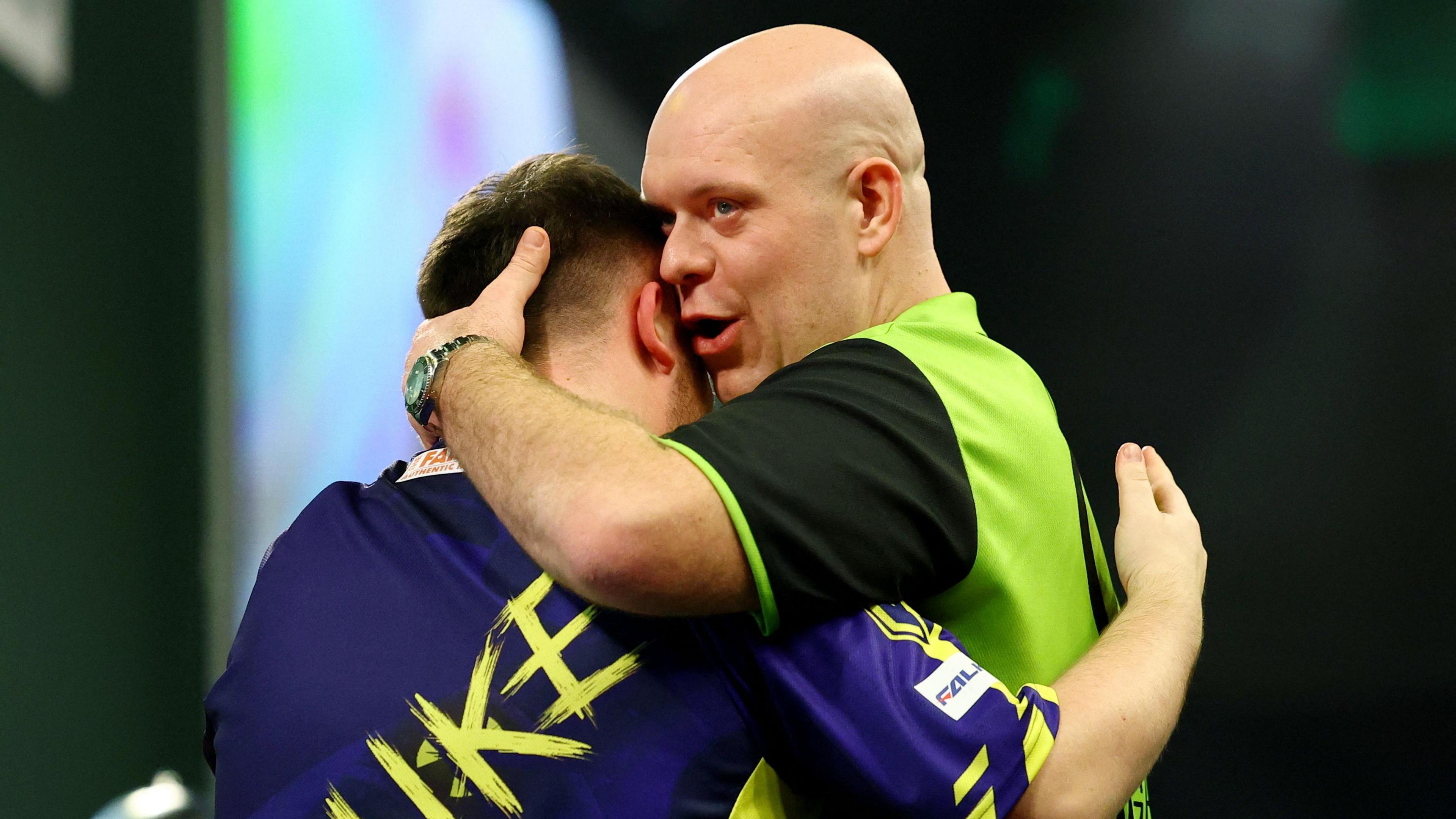 Michael van Gerwen embracing Luke Littler 