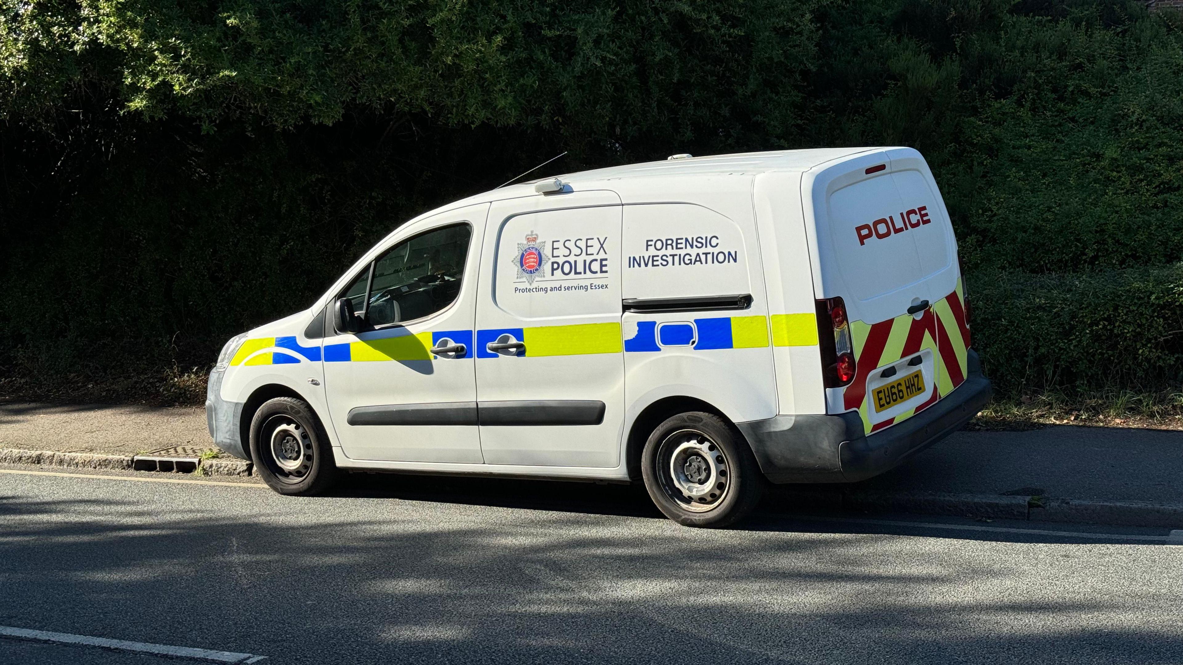 A white forensic investigation vehicle parked on a pavement