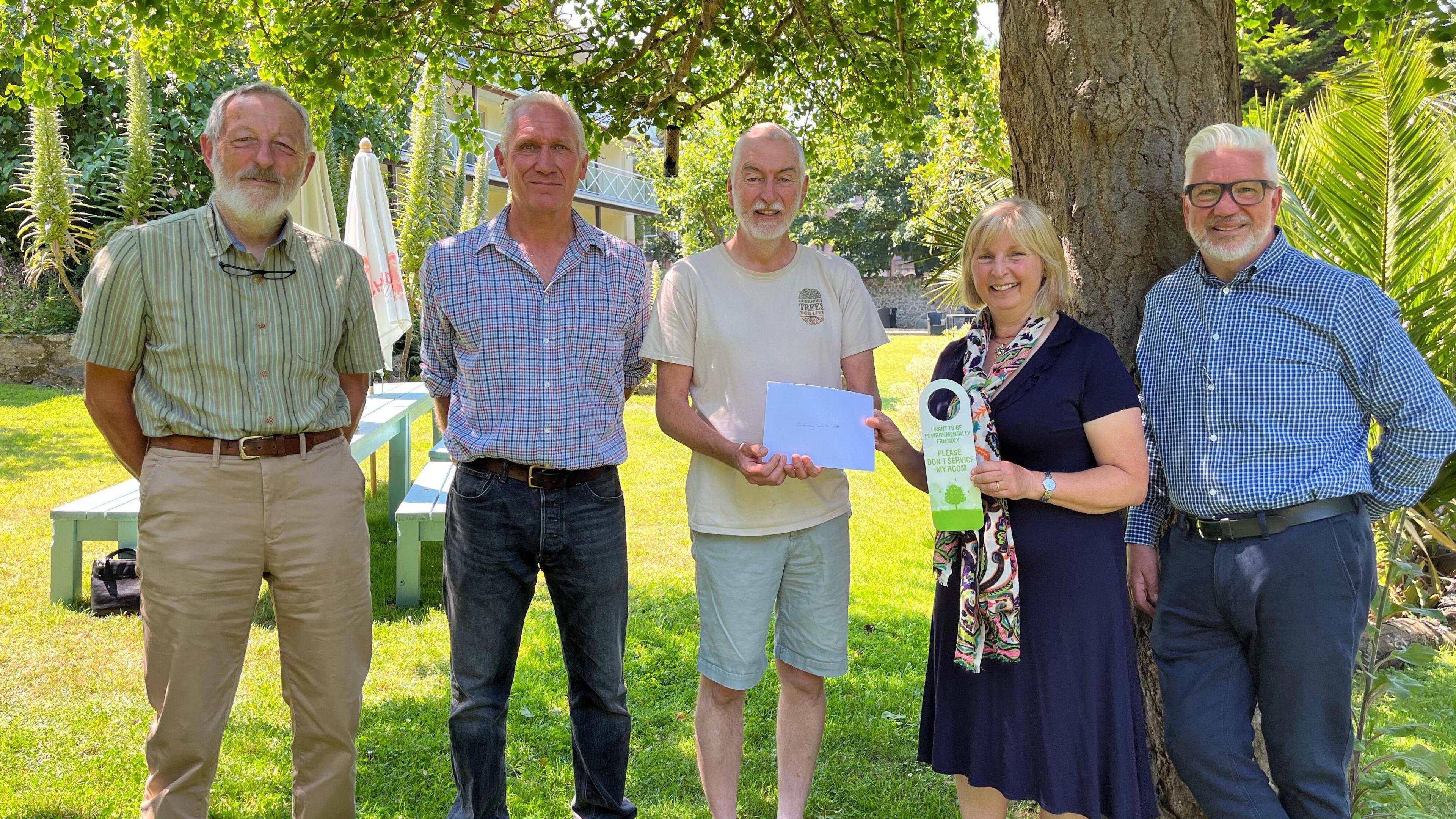 Sarnia hotels managing director handing over cheque to Trees for life Guernsey