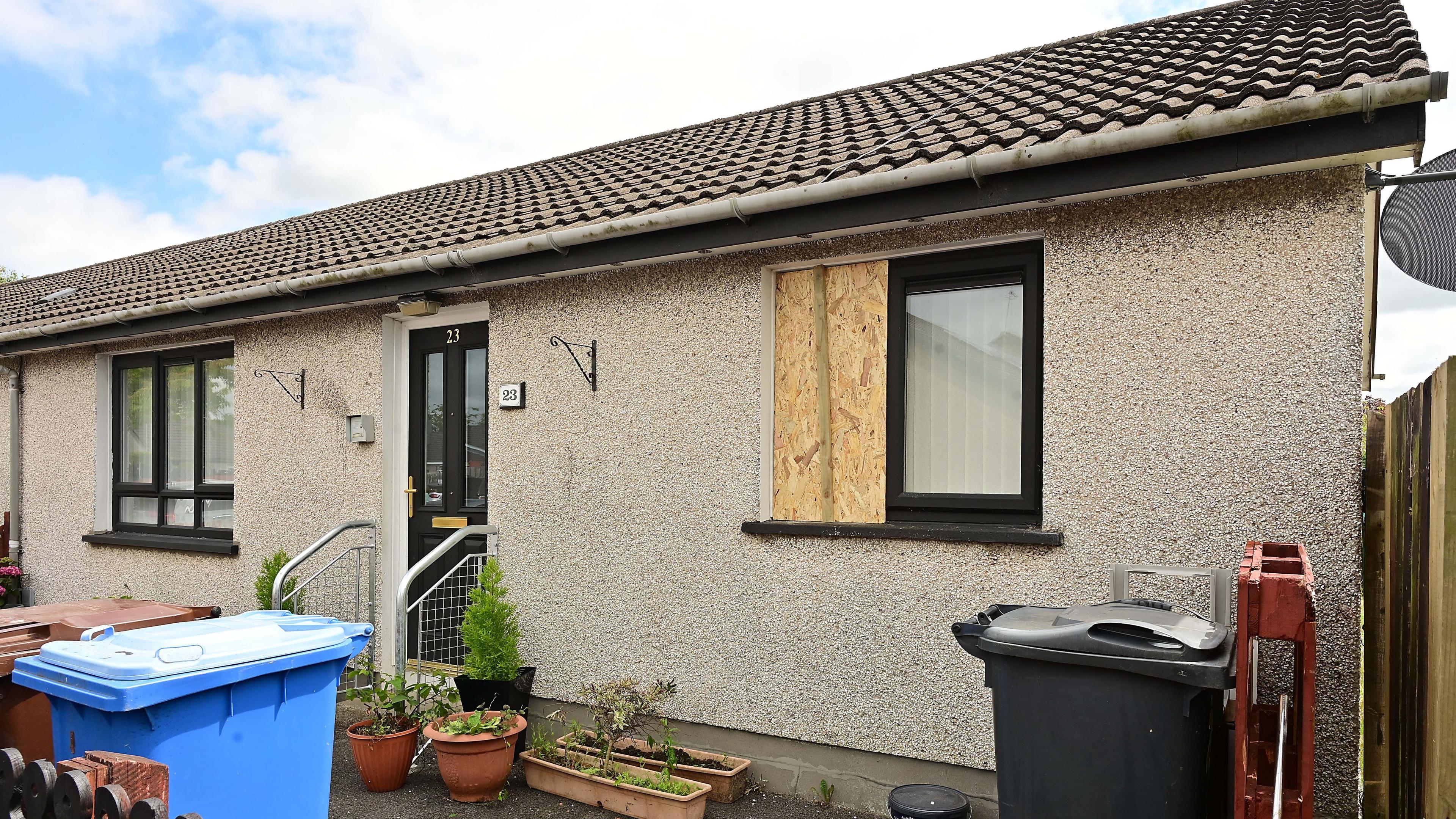 Bungalow with wooden boards on window