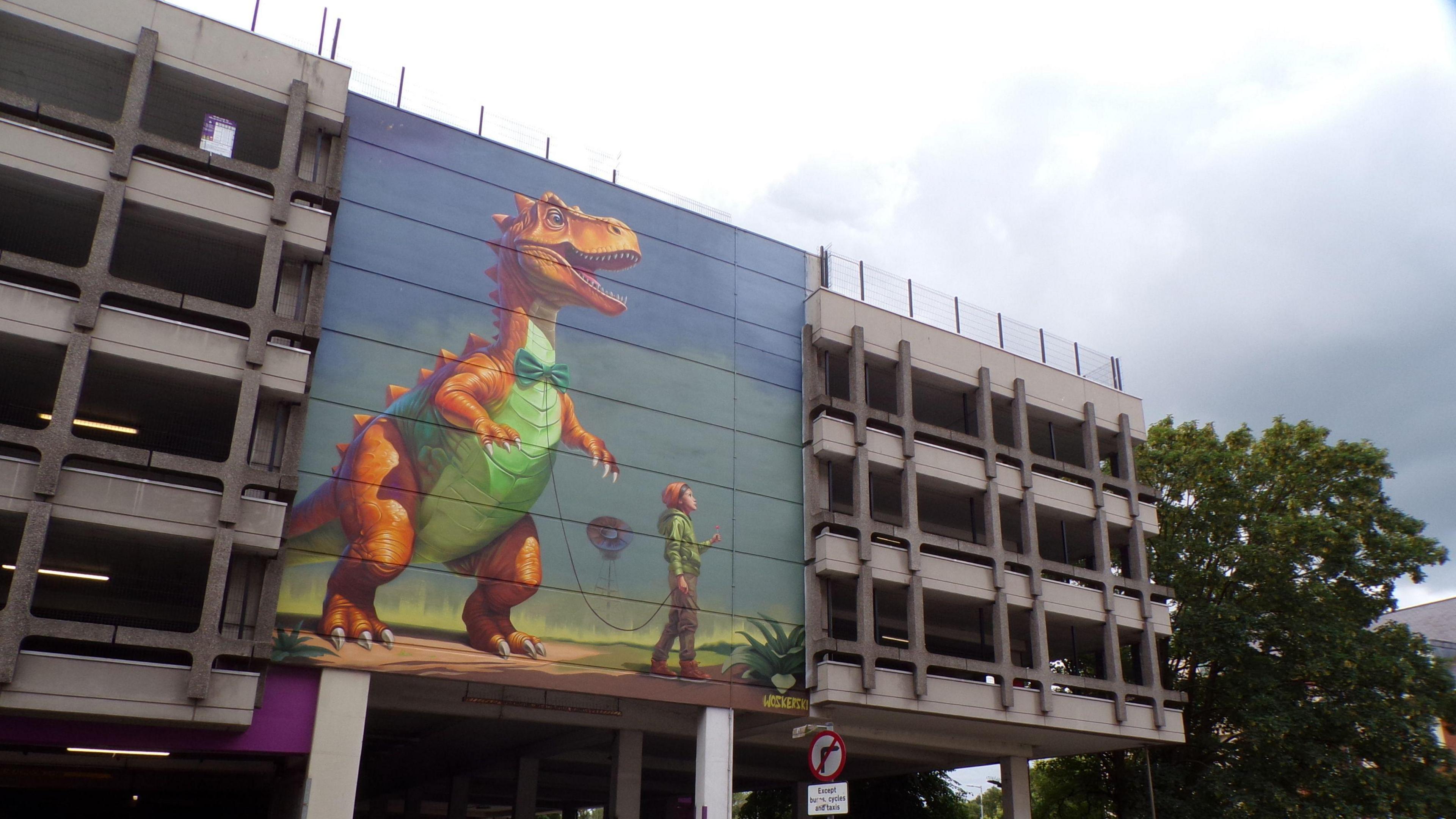 A street art image of a dinosaur being walked by a boy