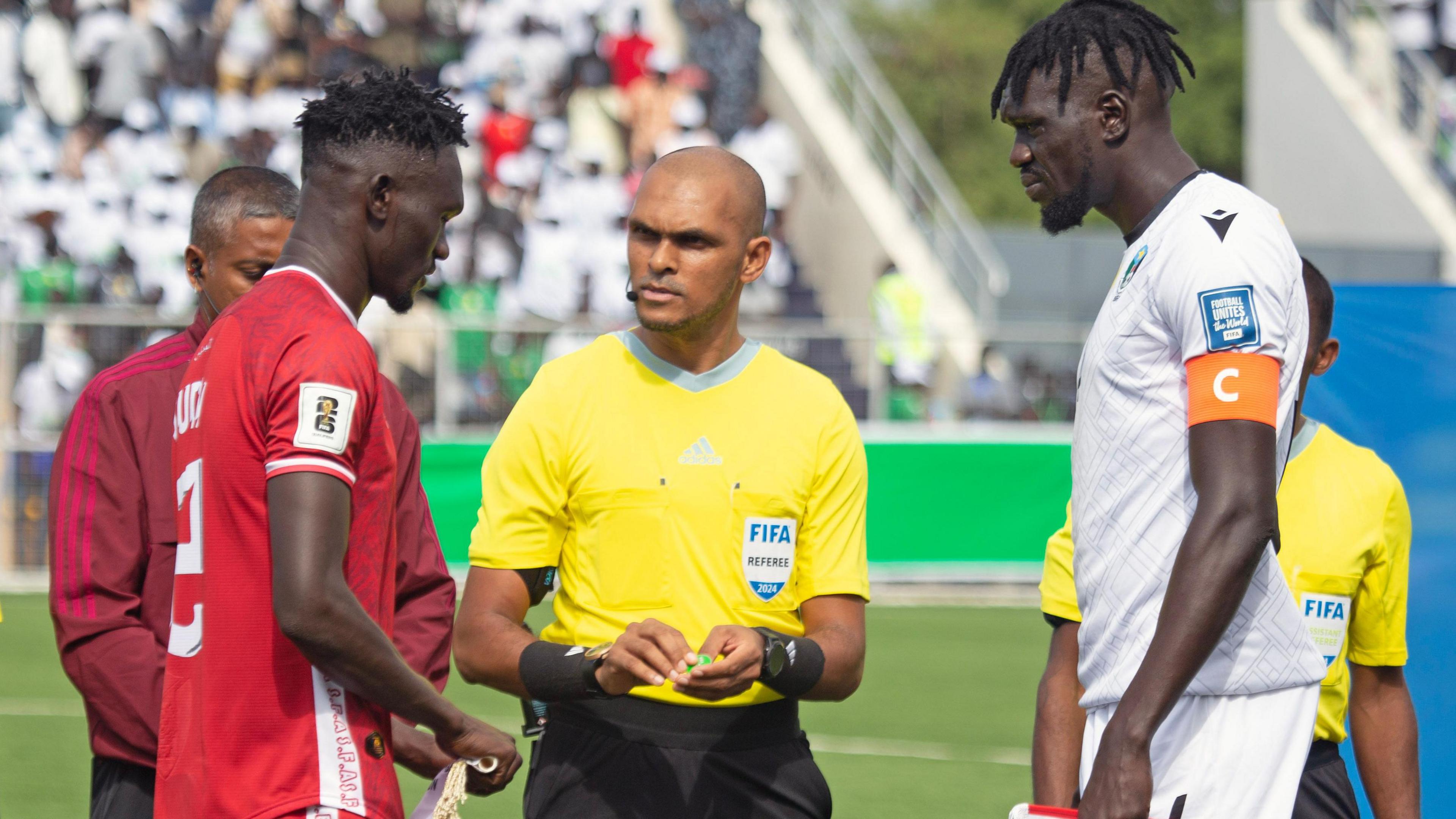 Sudan captain Bakhit Khamis prepares for a coin toss with South Sudan skipper Peter Maker