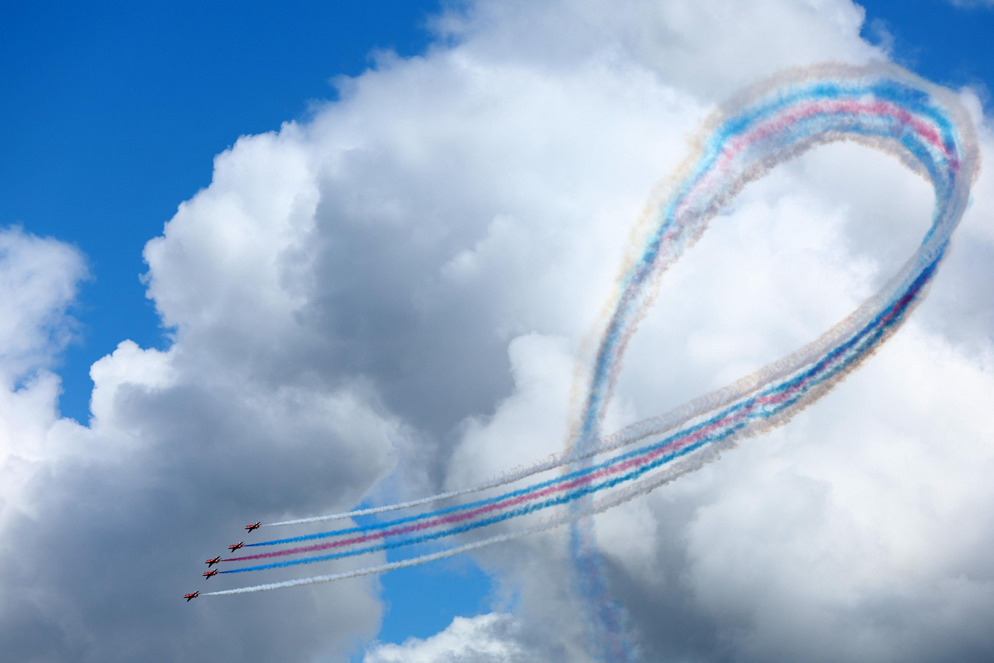 The Red Arrows performing an aerial stunt with coloured vapour trails