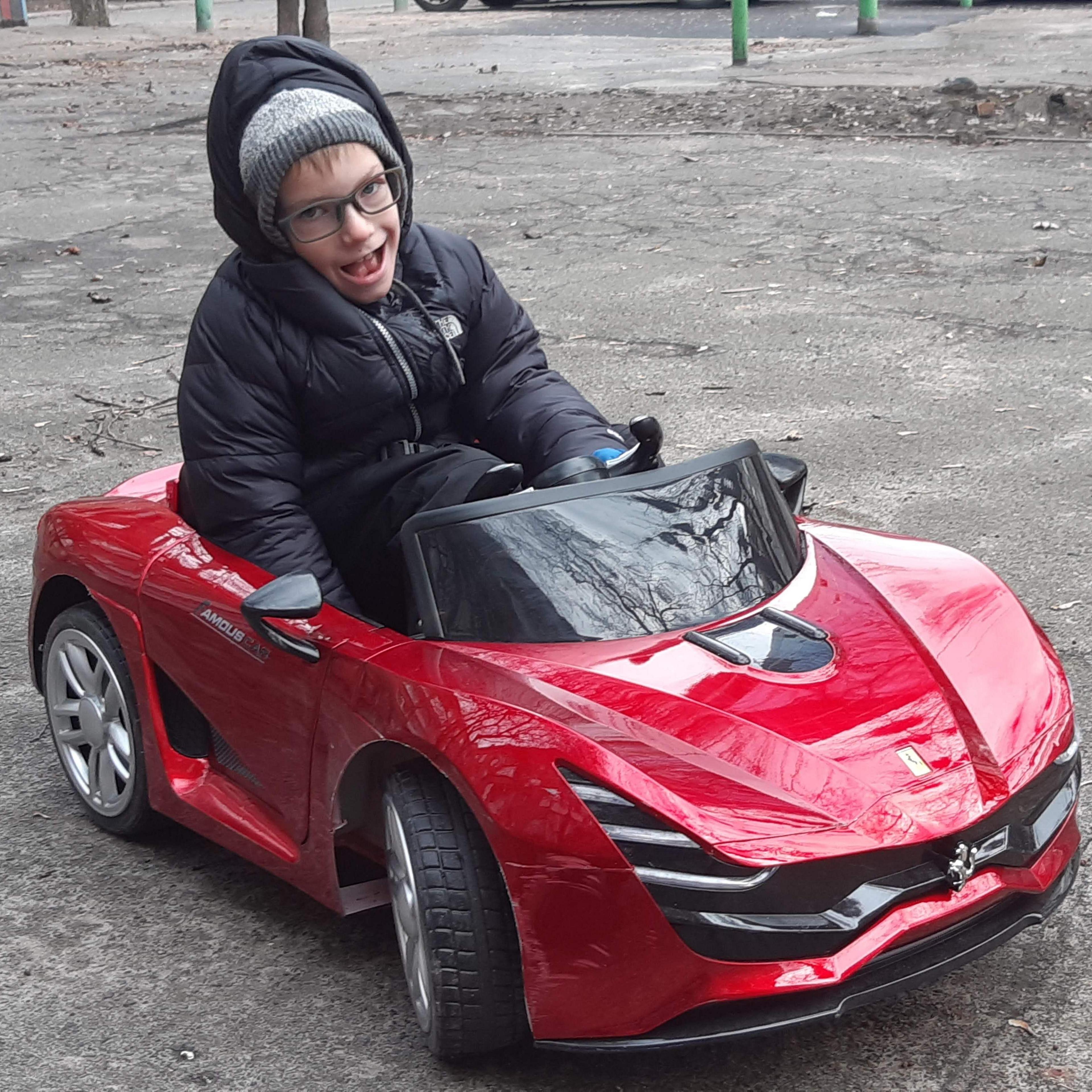 Mikhailo in a red play car