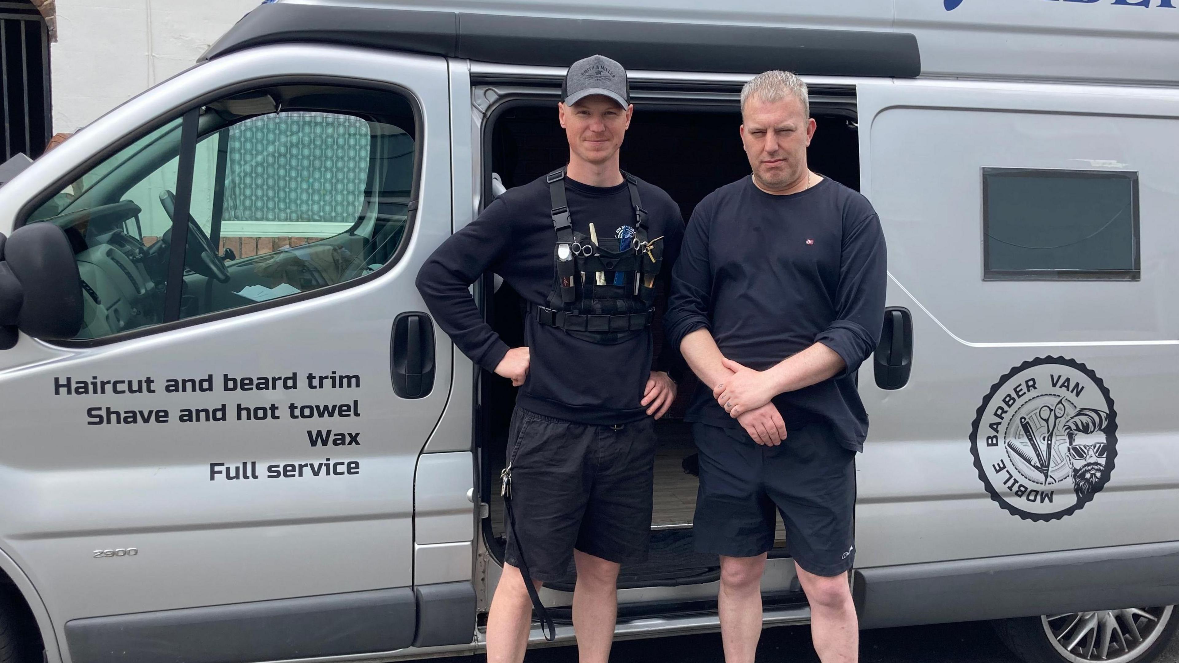 Mr Vorobets and Mr Edward are pictured in front of the silver mobile barber van 