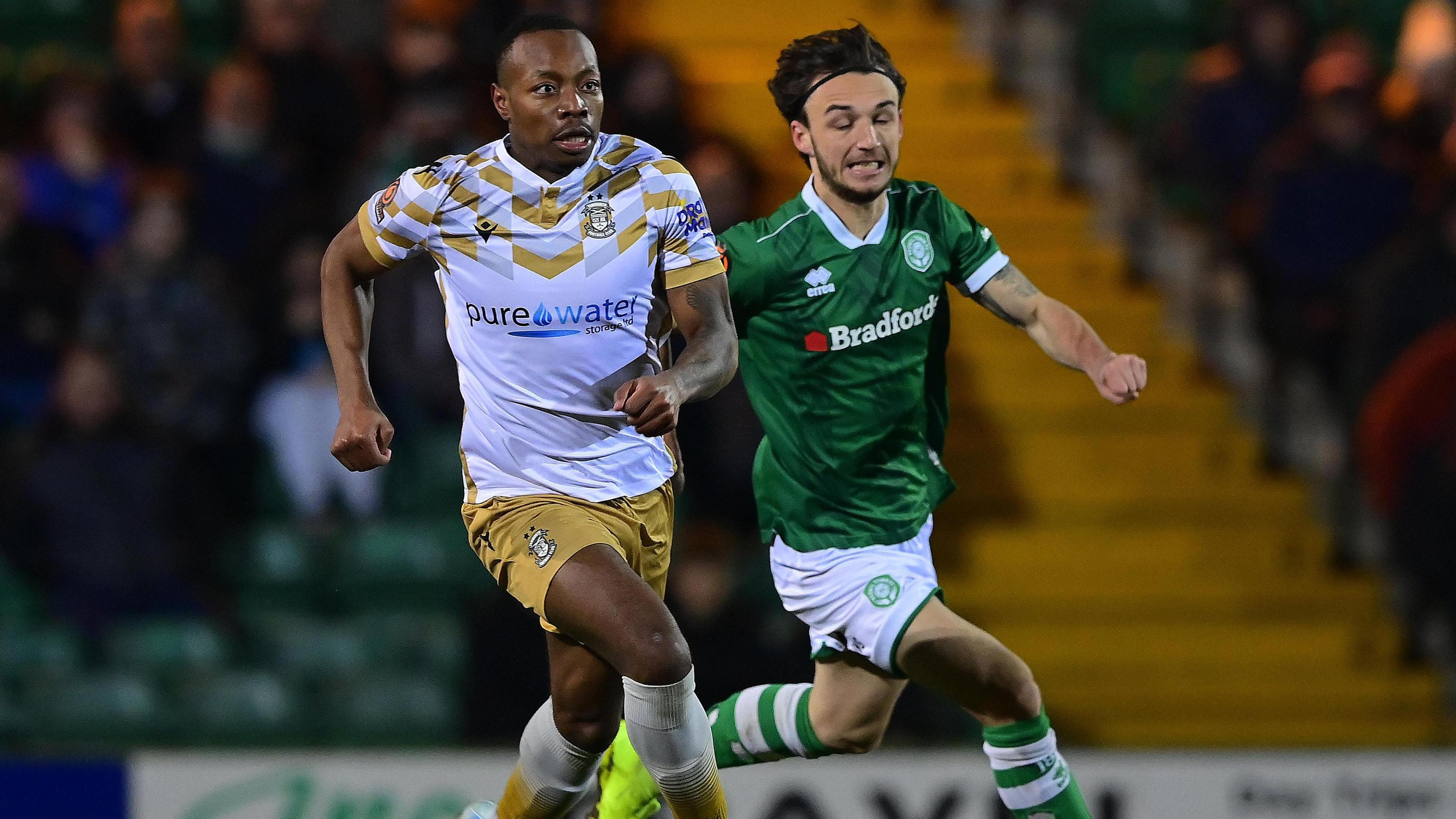 Munashe Sundire (left) running with the ball during a match for Tamworth
