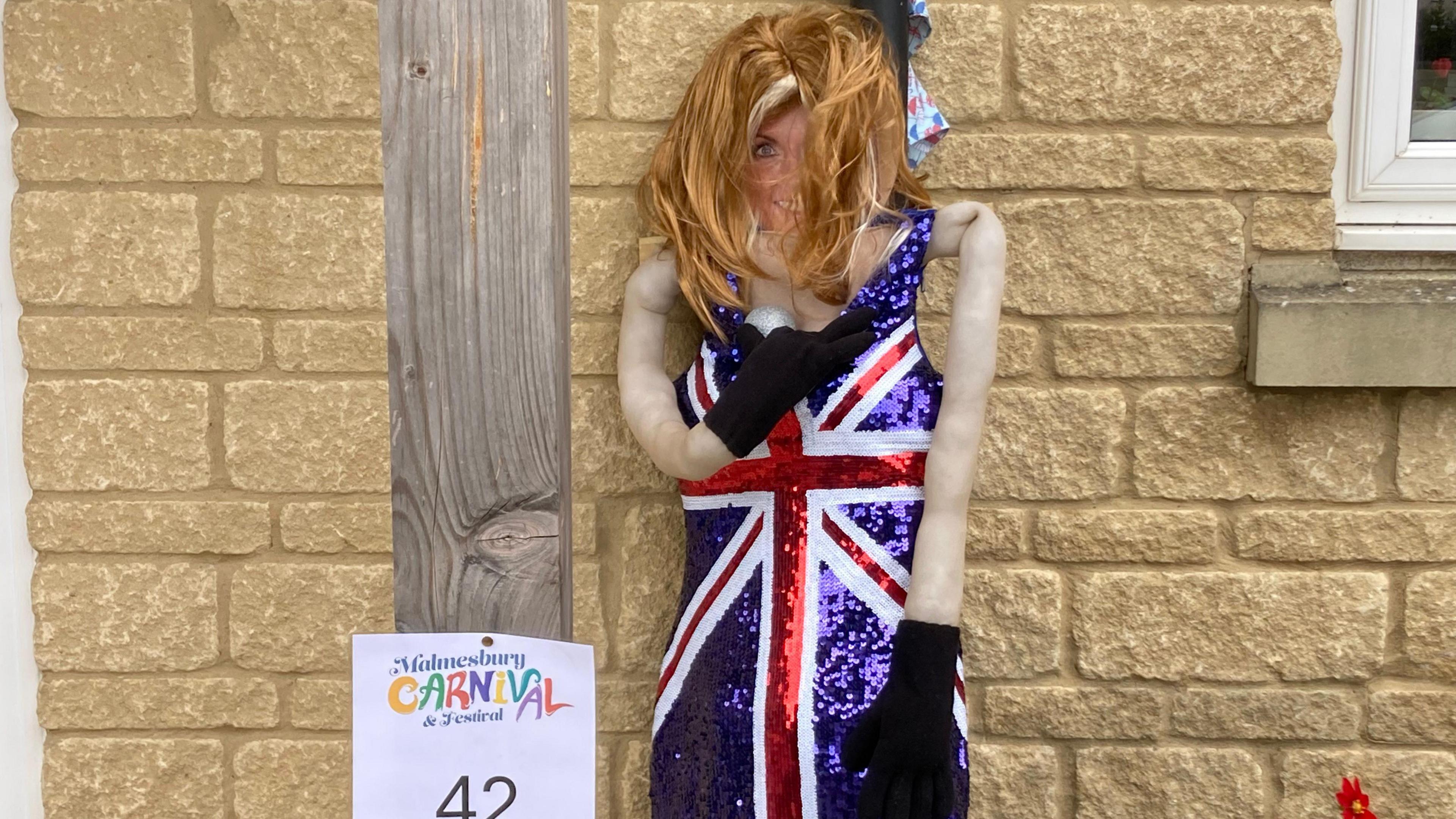 A scarecrow of Geri Halliwell. There is a ginger wig on the scarecrow and it is wearing a sparkly Union Jack dress.