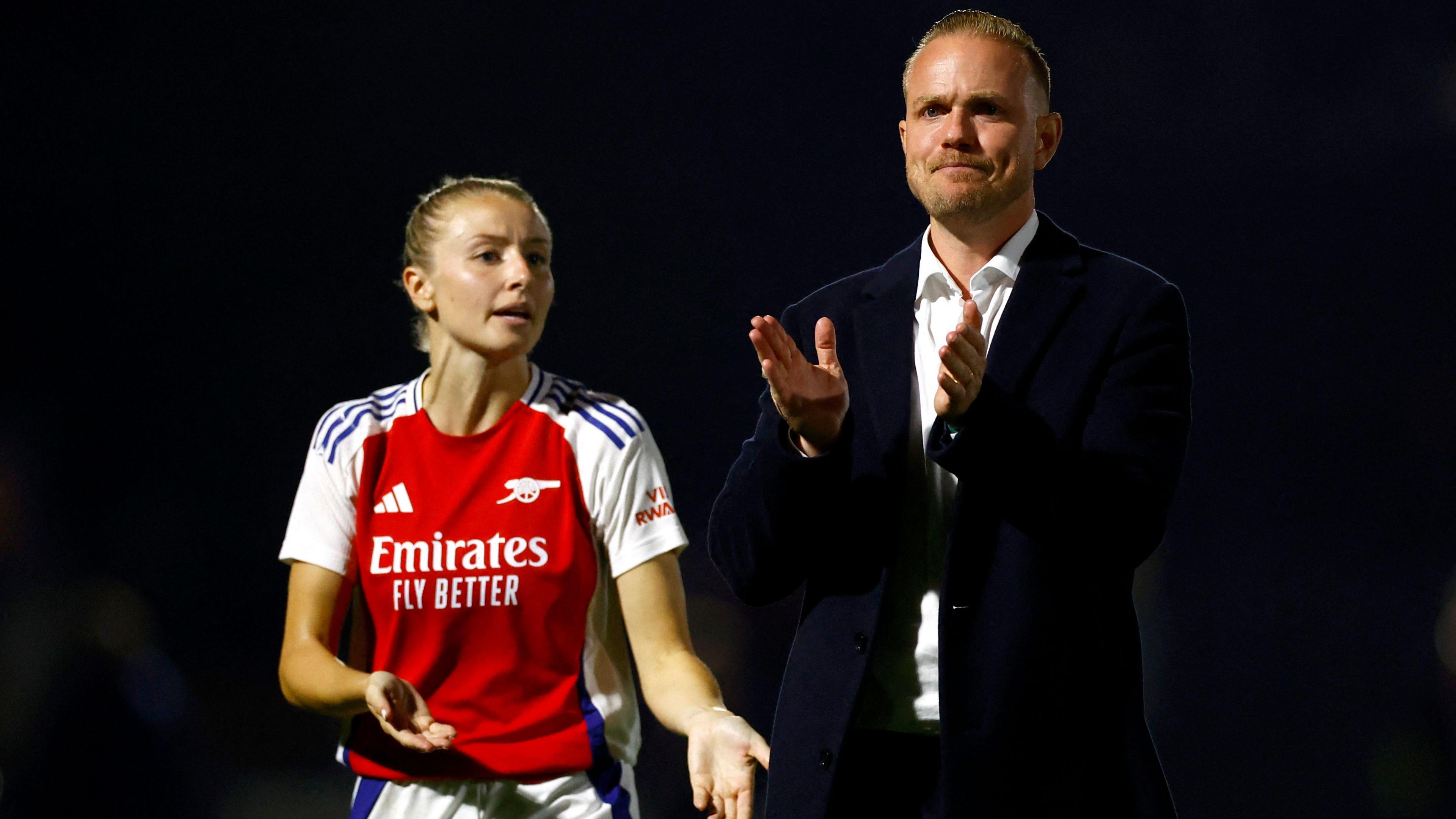 England captain Leah Williamson (wearing an Arsenal shirt) appears to look frustrated on the field next to Jonas Eidevall. 