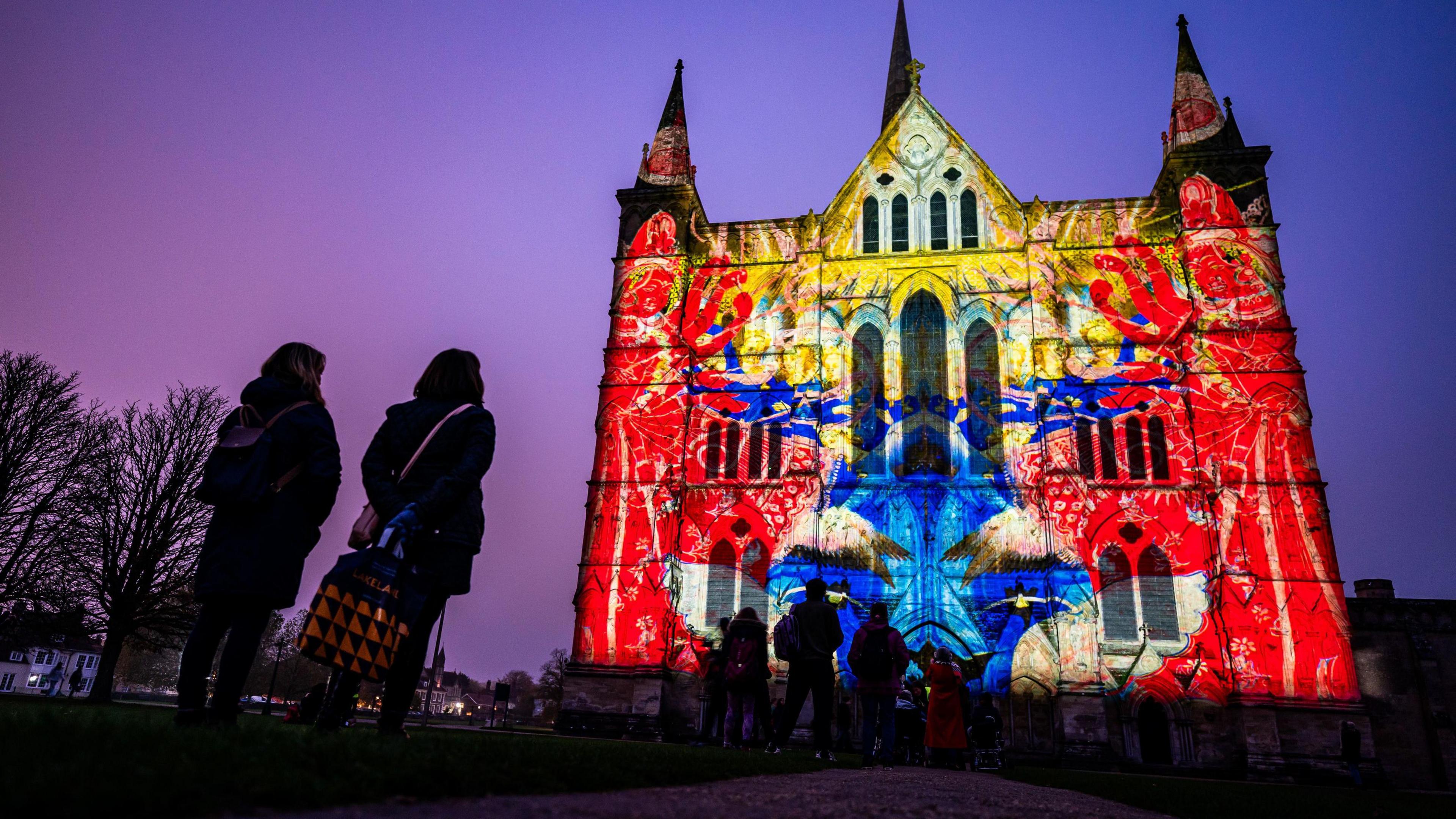 Onlookers watch a light display projected on to Salisbury Cathedral