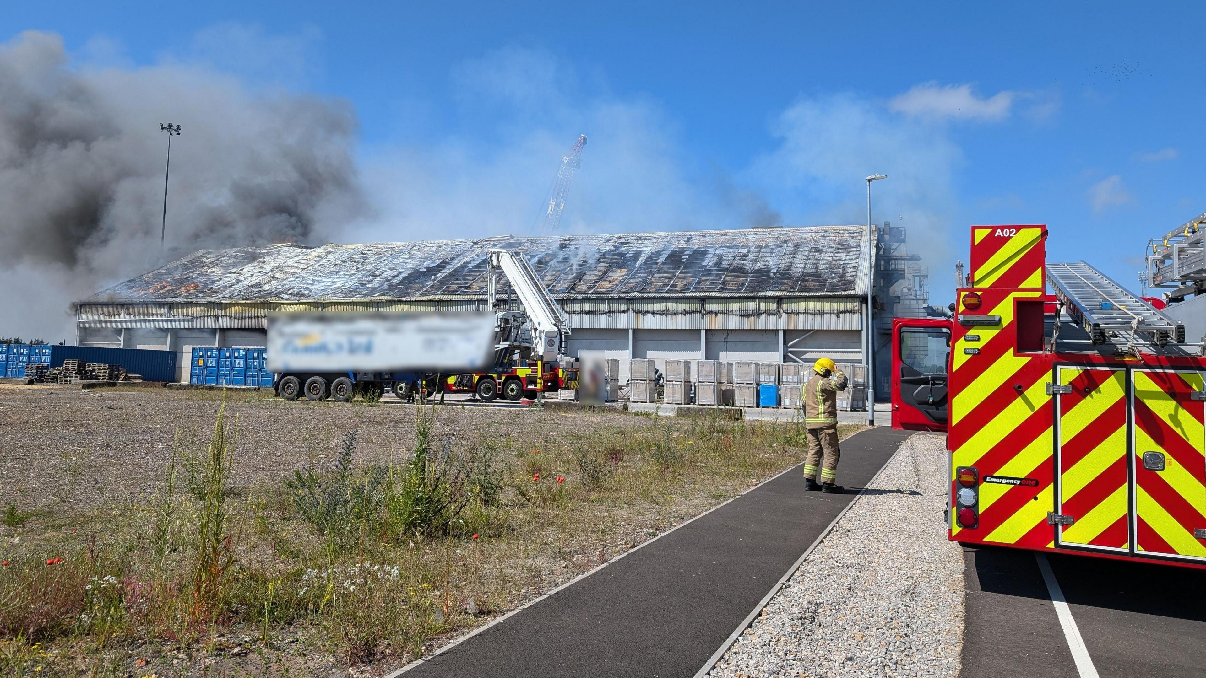 A fire engine parked near the smouldering building