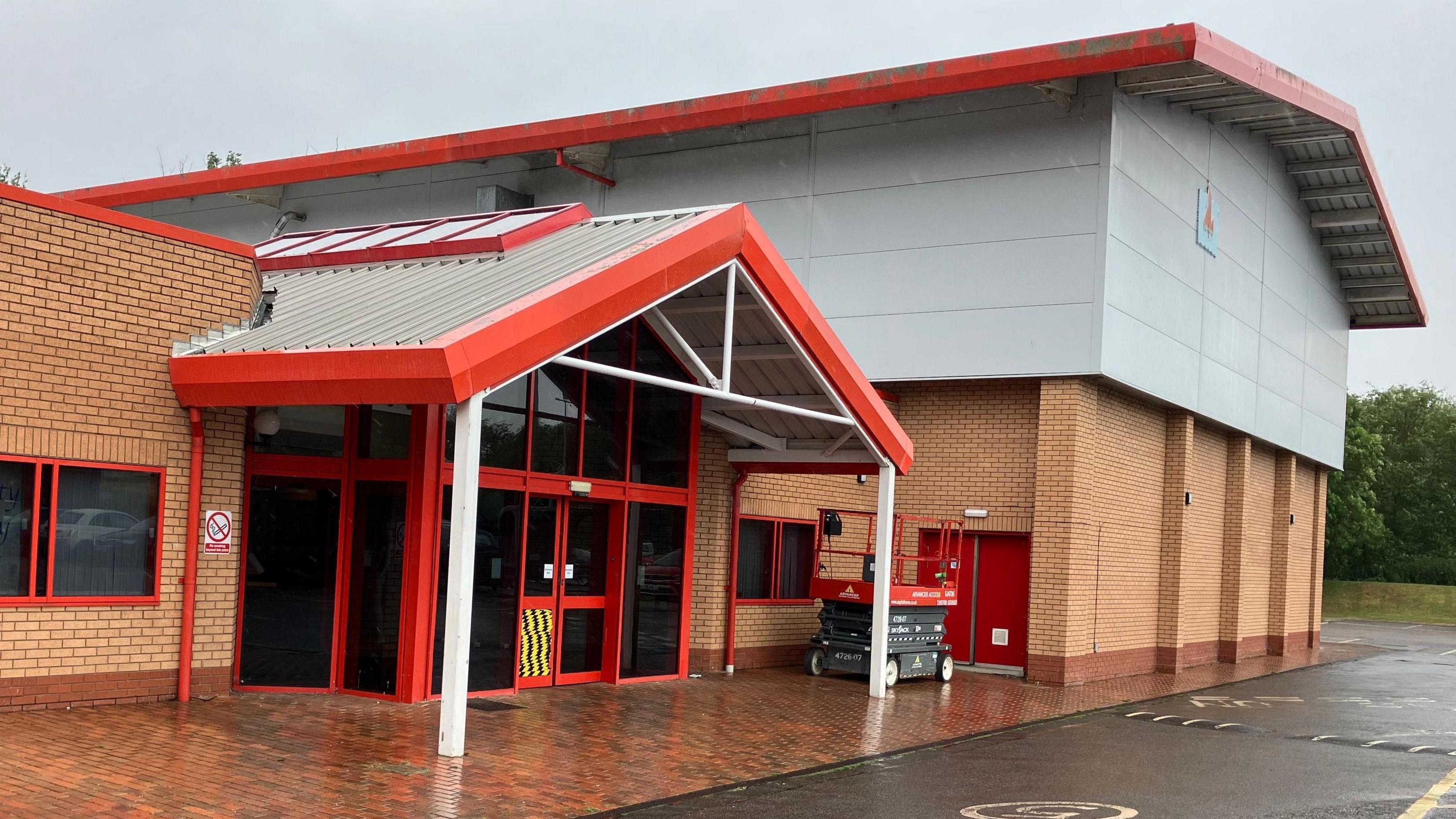 The entrance to the Blackwater Leisure Centre, which is a brick building with a red and white canopy above its main doors.