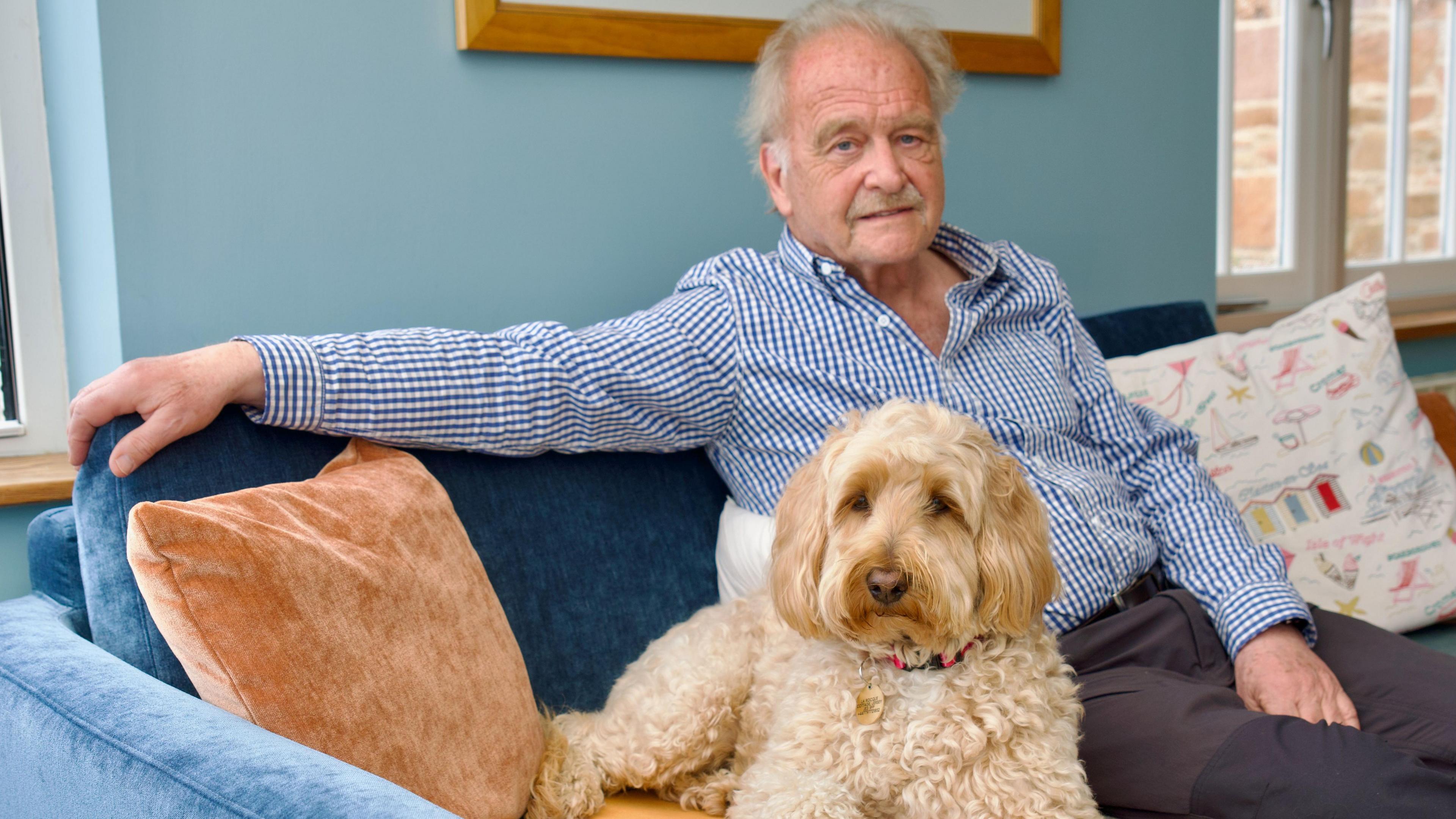 Colin Walker with dog Tilly on the sofa