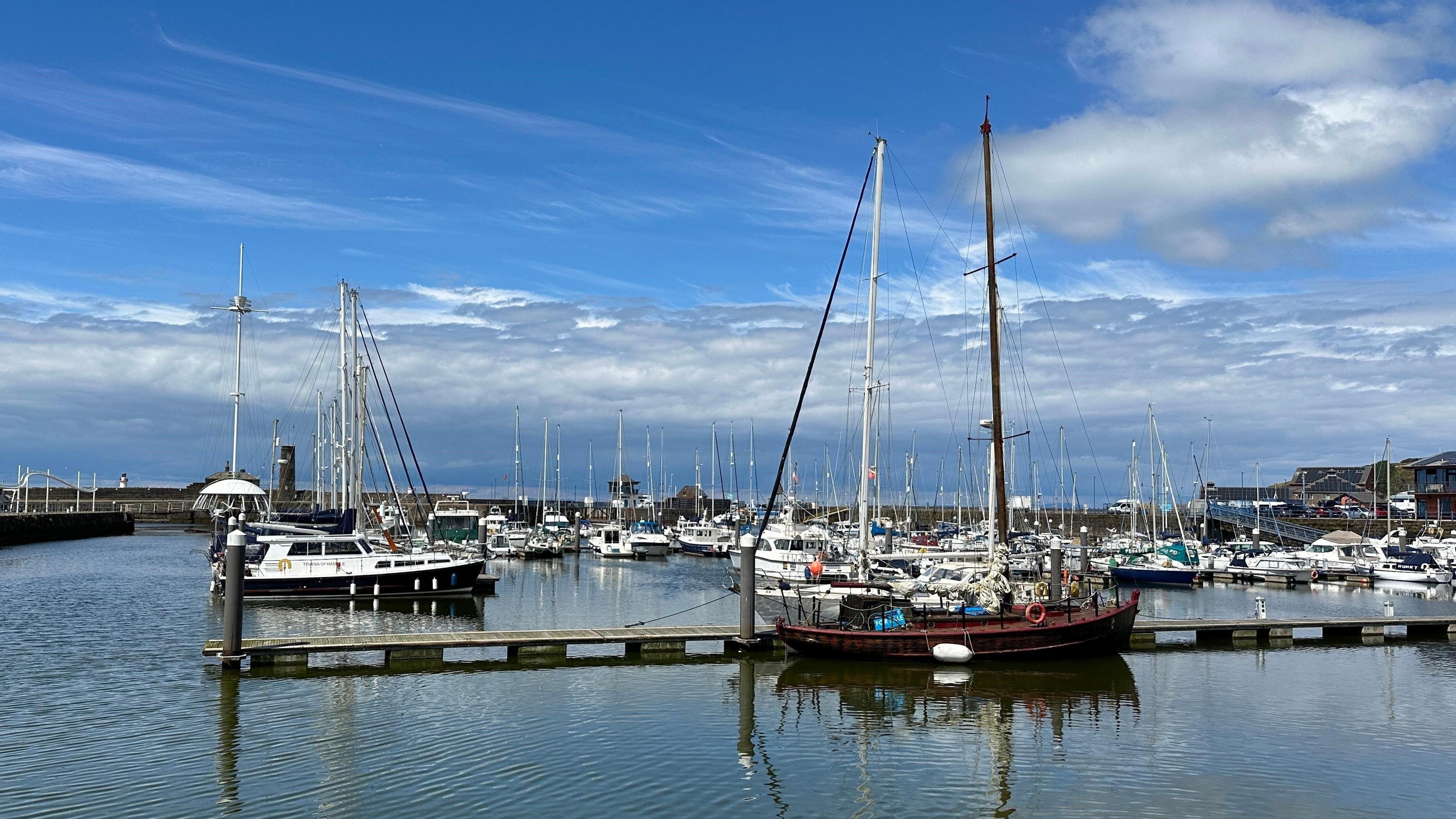 Small boats in a harbour with a bank of cloud on the horizon