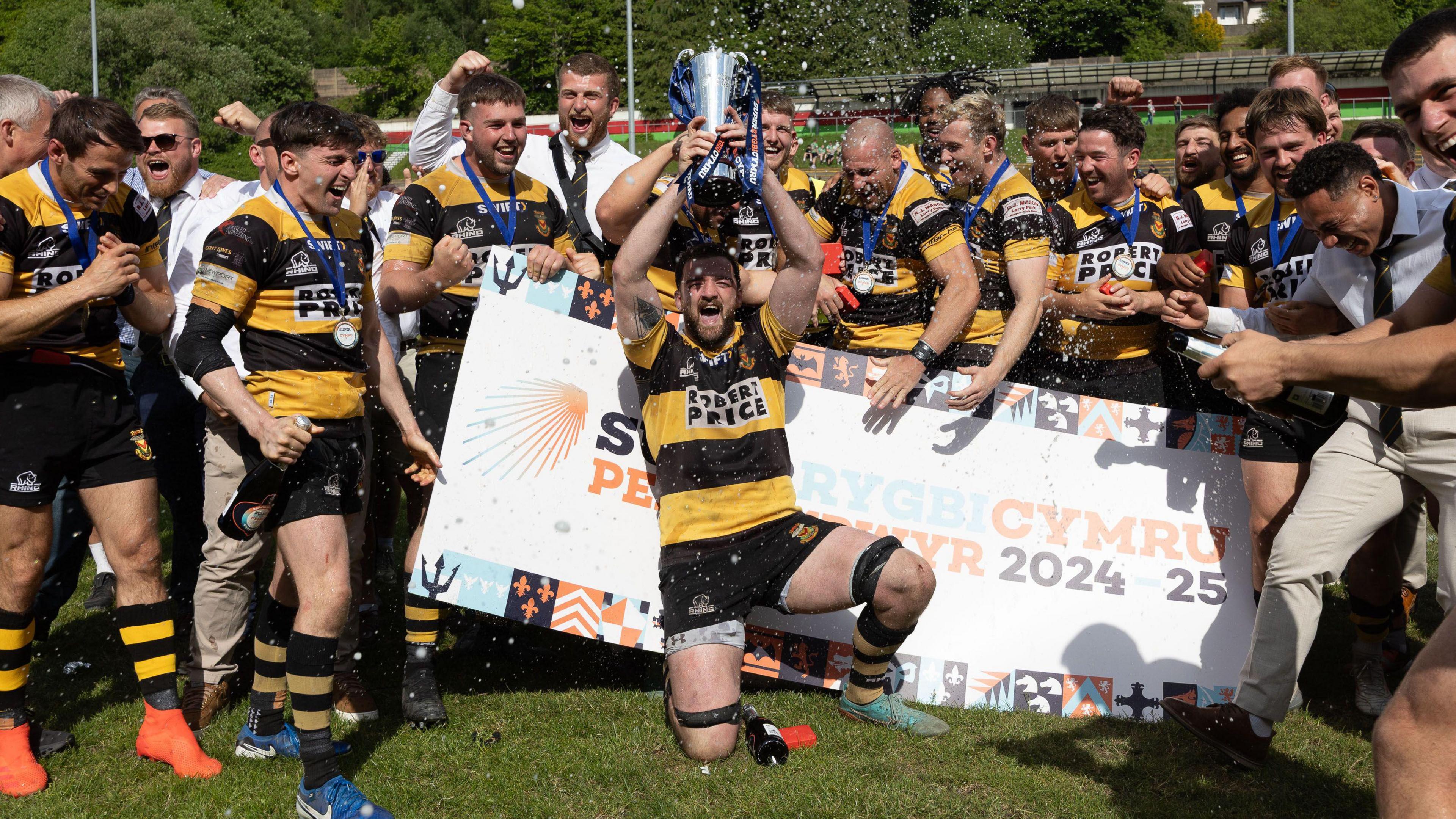 Captain Ben Roach lifts the SRC trophy as his Newport teammates celebrate their win in the final at Ebbw Vale