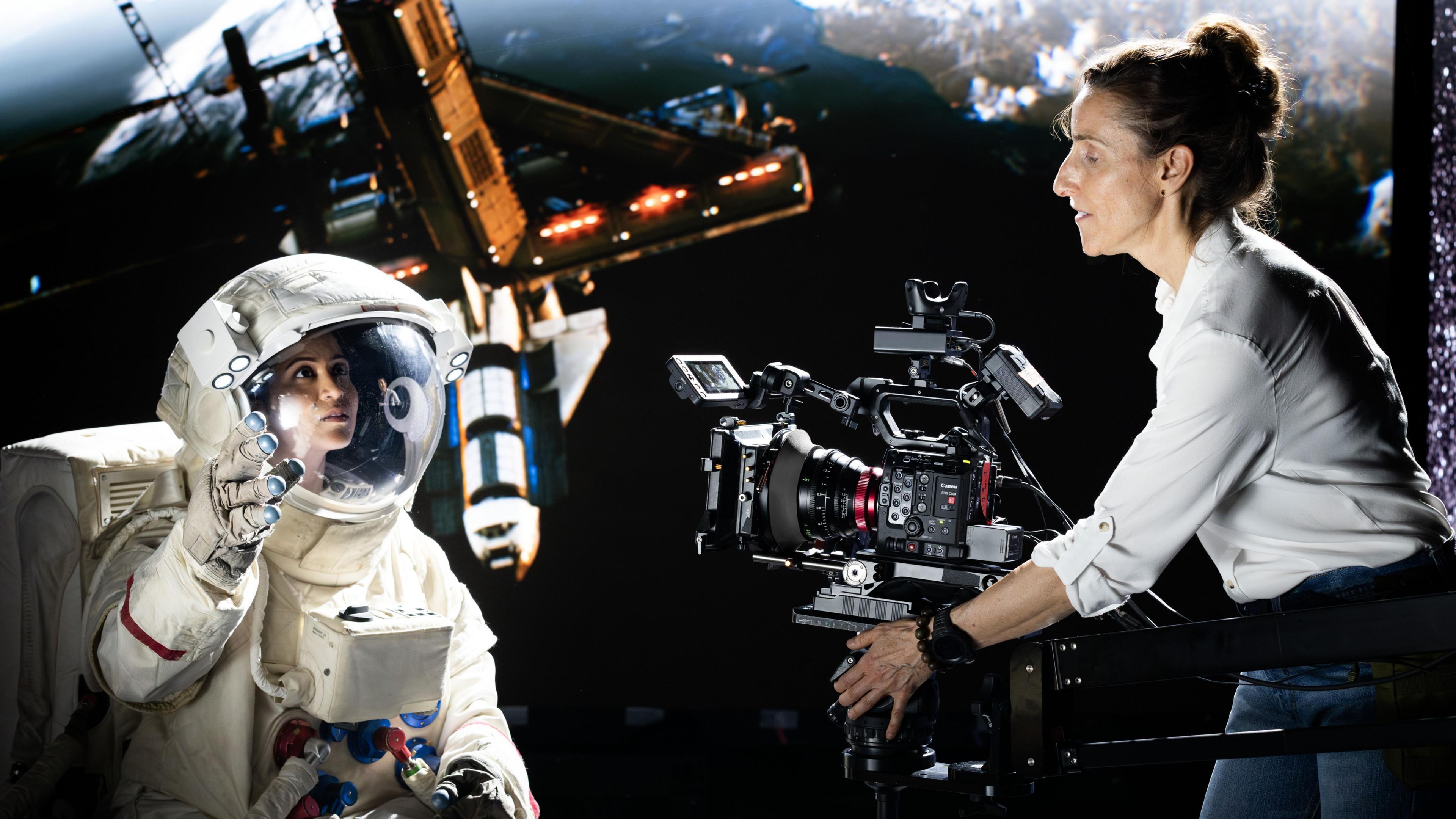 A camera operator films a seen with an astronaut