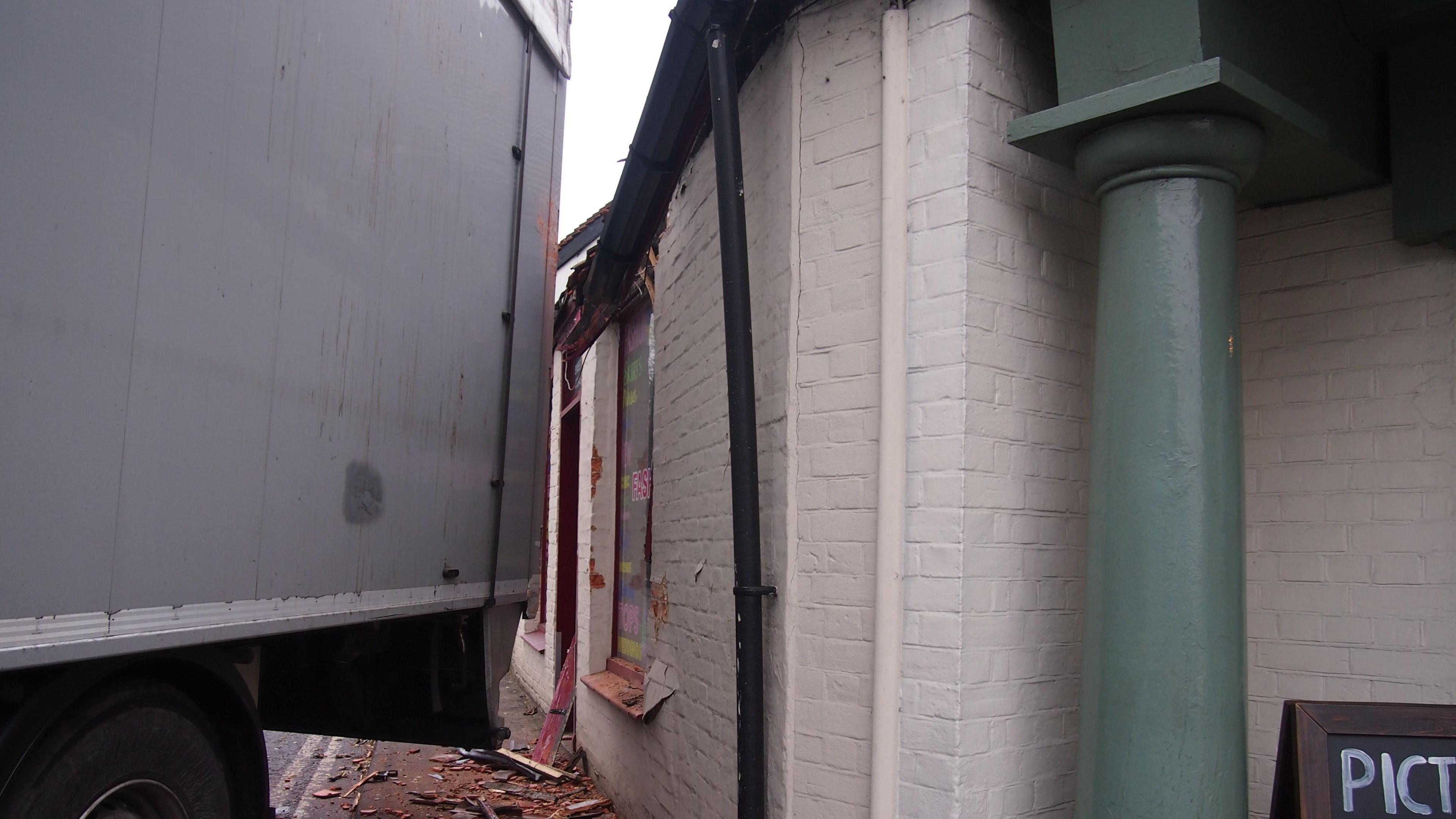 Smashed tiles on the pavement due to a lorry hitting a business