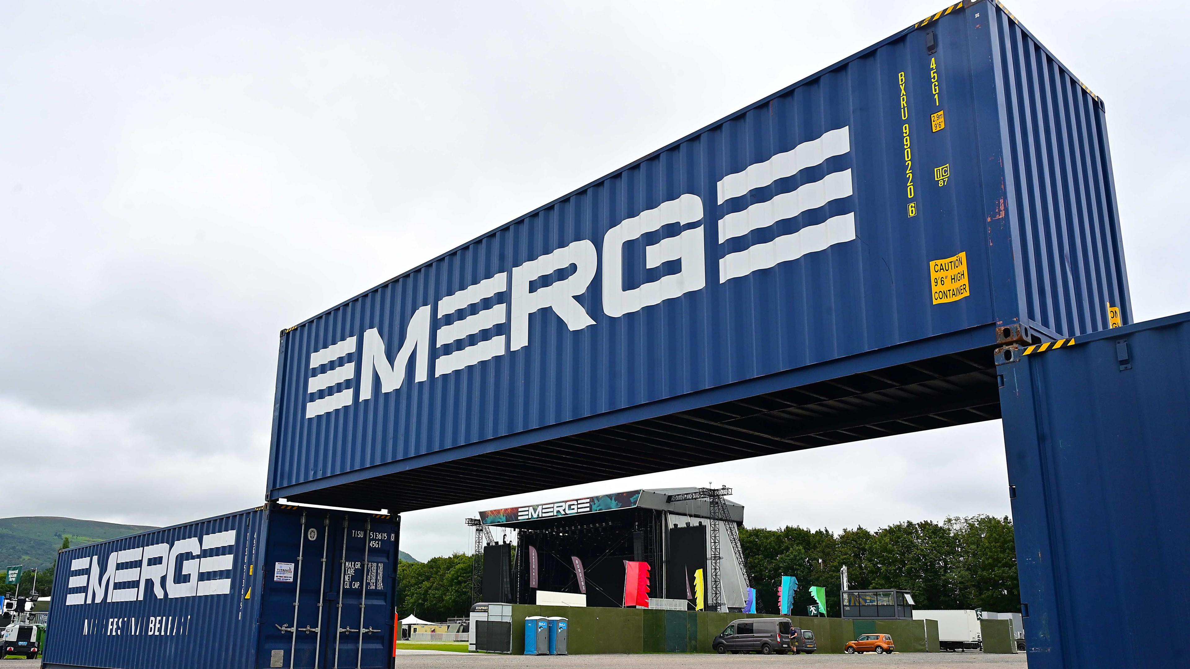 Blue shipping containers with Emerge printed on them in white writing