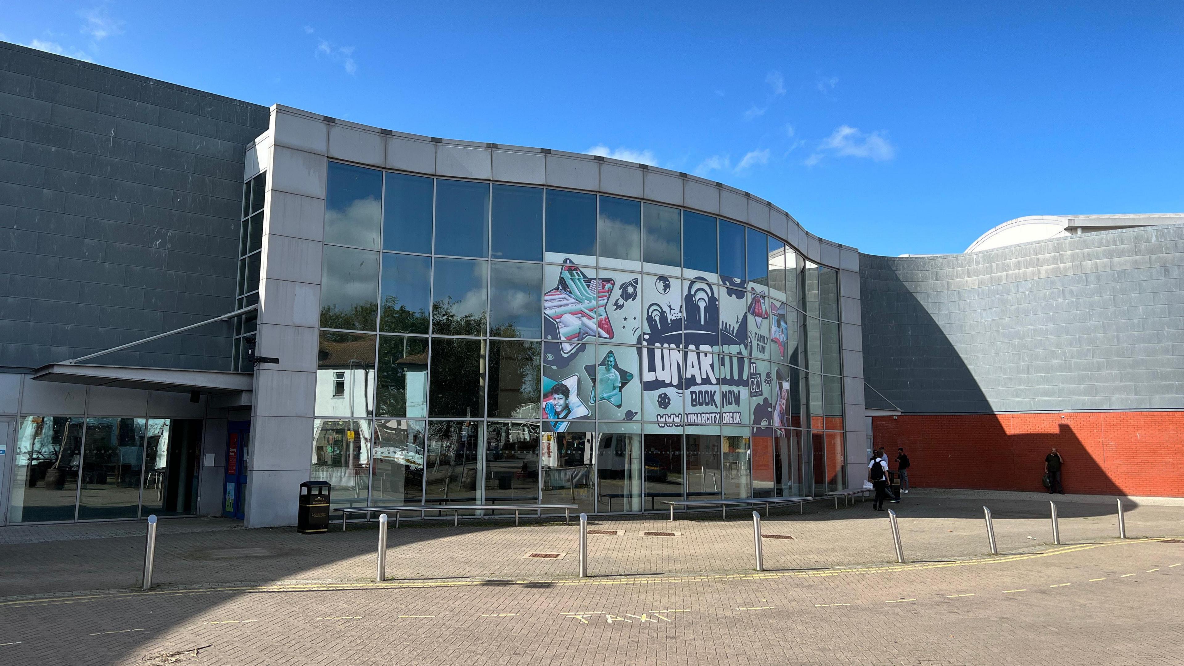 A building made of grey and red painted bricks and glass. 