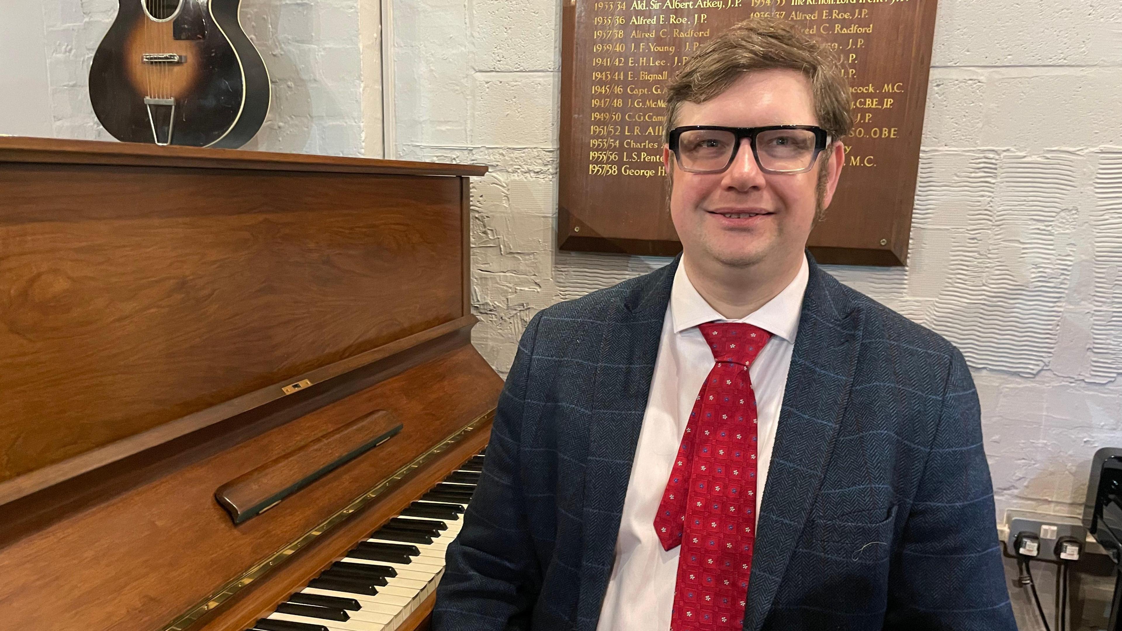 Stephen Bullamore sat on stool next to piano