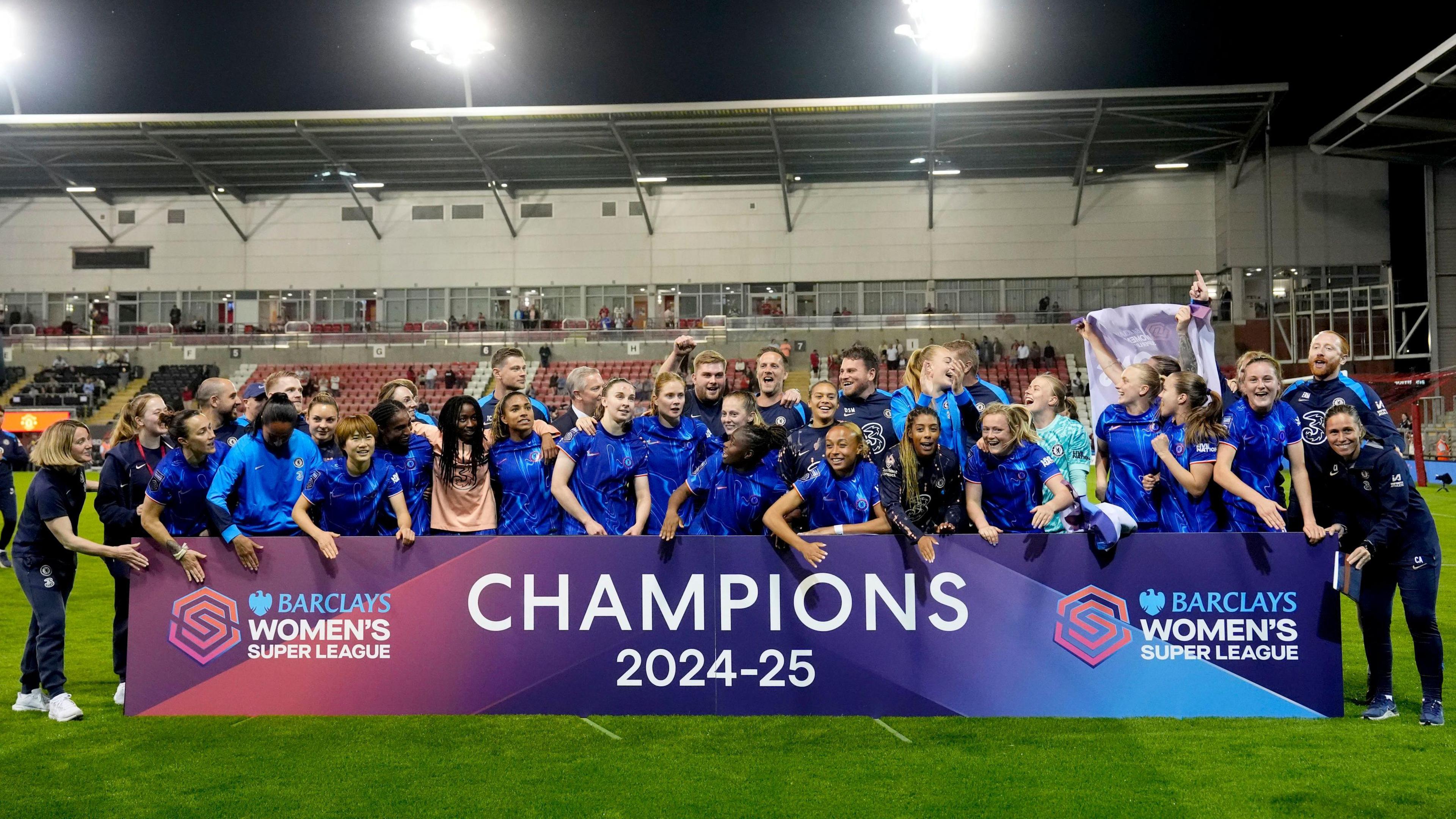 Chelsea players celebrating in front of a sign that reads Champions 2024-25.